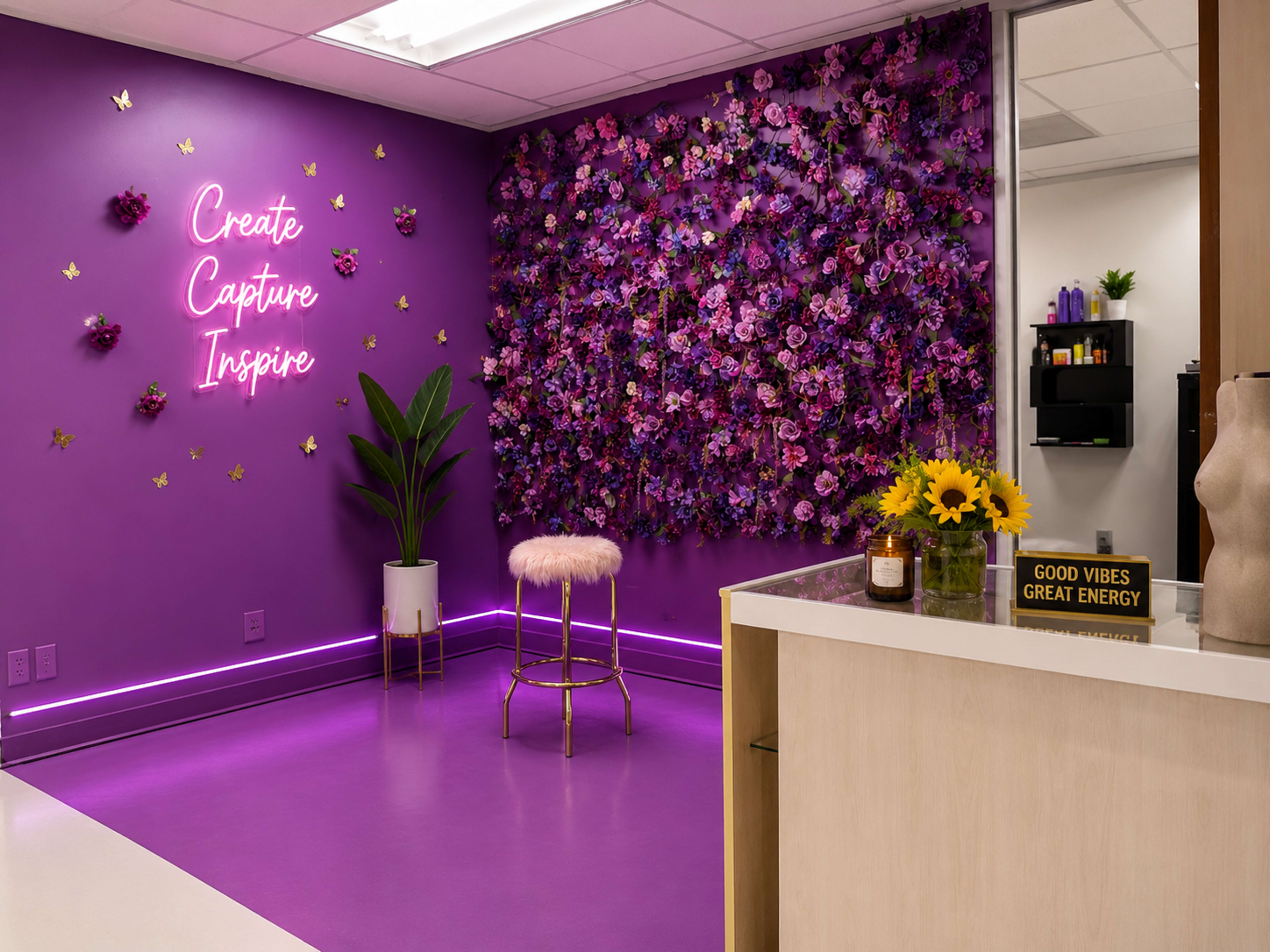 The image shows a vibrant purple room decorated with a floral wall, a stool, and a reception area featuring a vase of sunflowers.