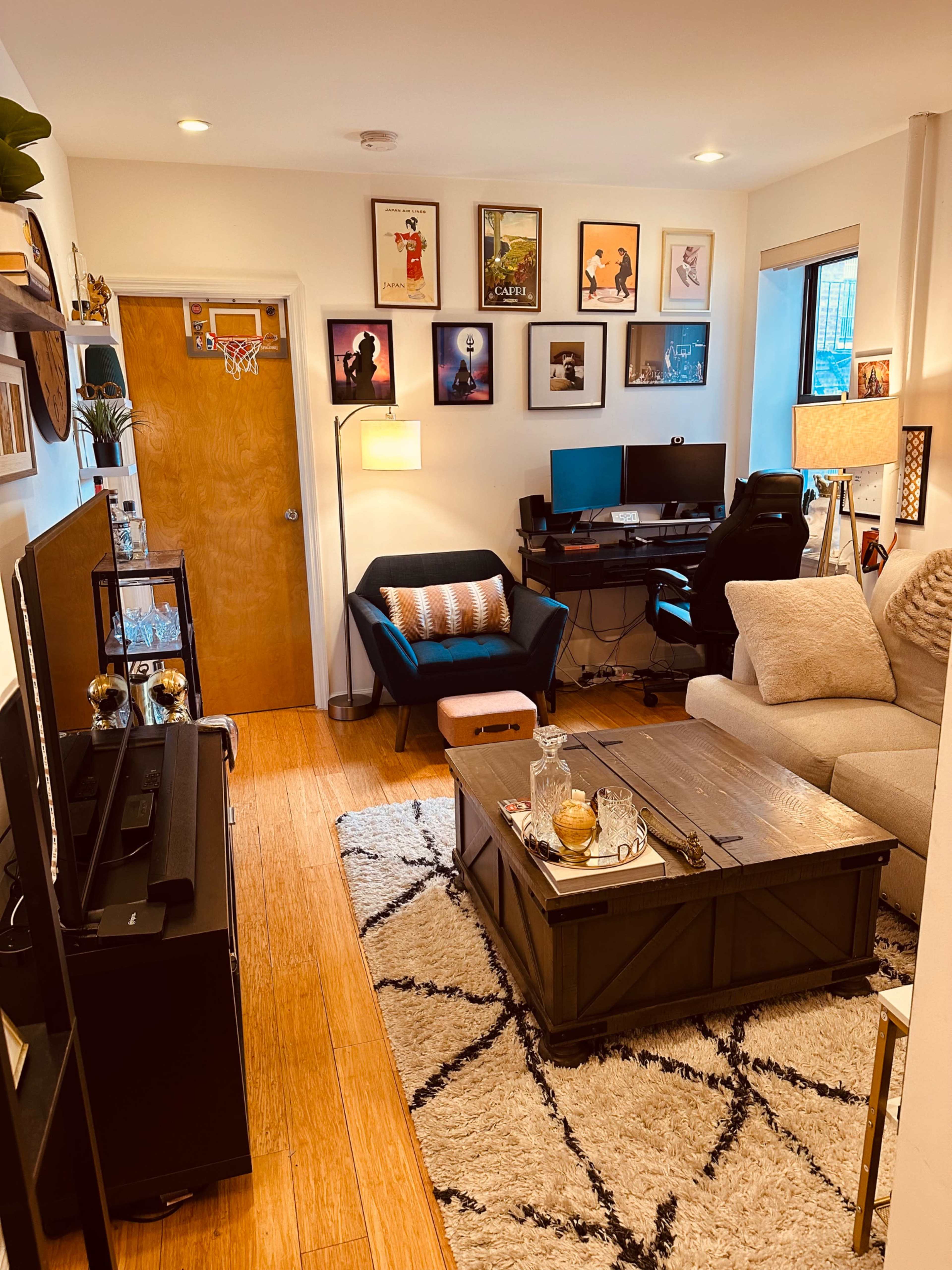 A cozy living room with a seating area, a coffee table, and walls adorned with framed artwork.