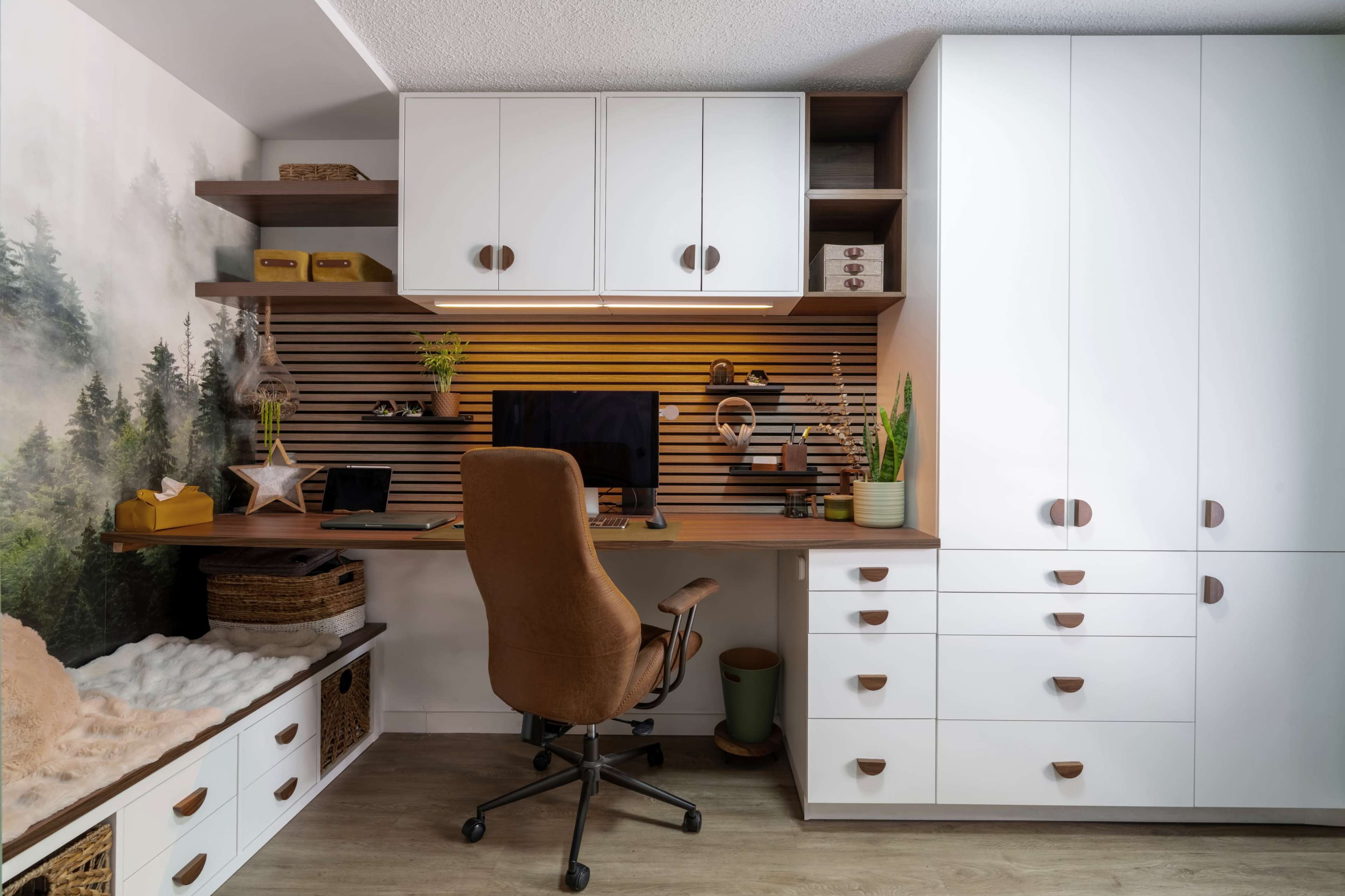 The image shows a modern home office with a desk, chair, and storage units, featuring a nature-themed mural in the background.