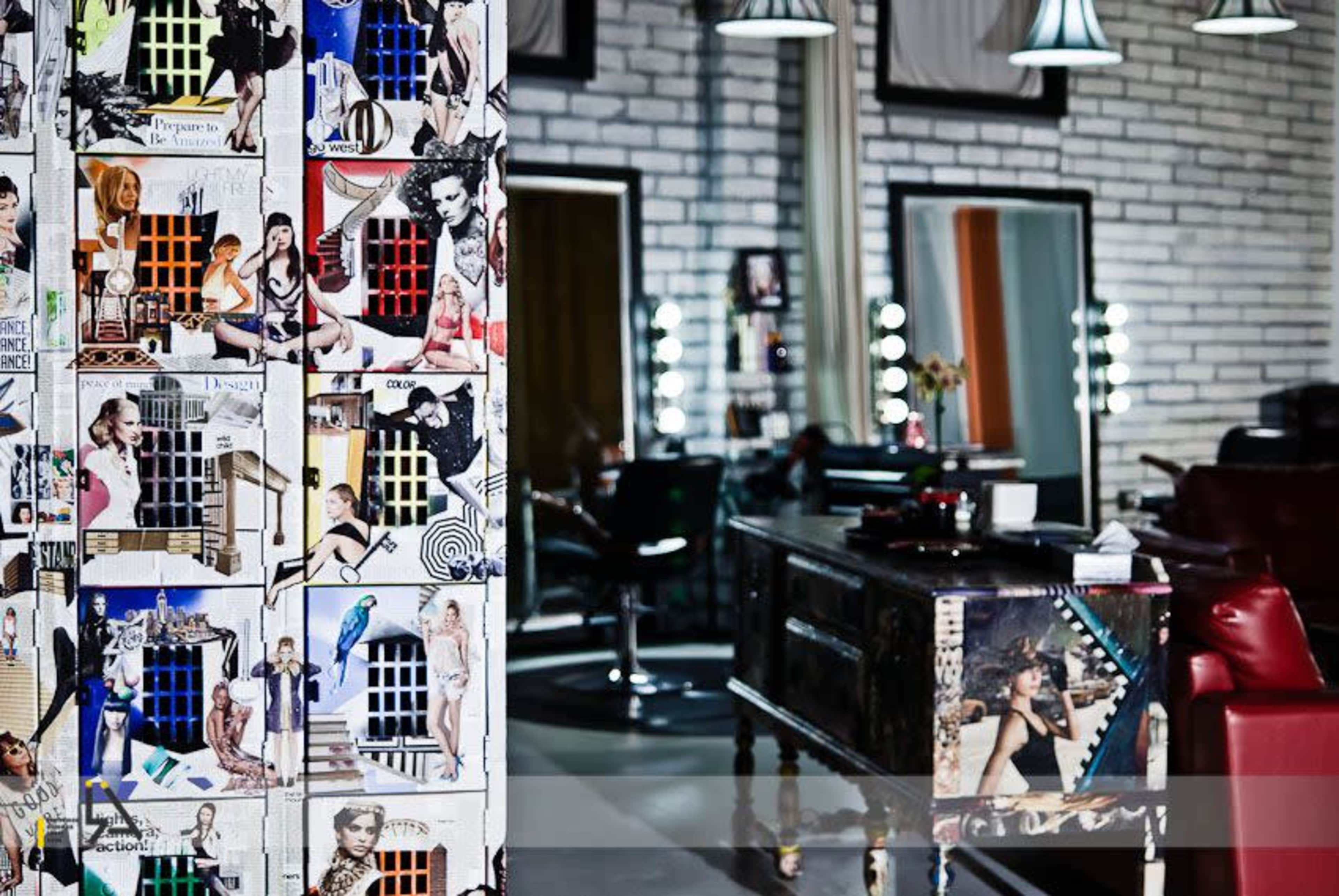 The image shows a stylish hair salon interior featuring a decorative wall adorned with colorful collages and a modern styling station in the background.