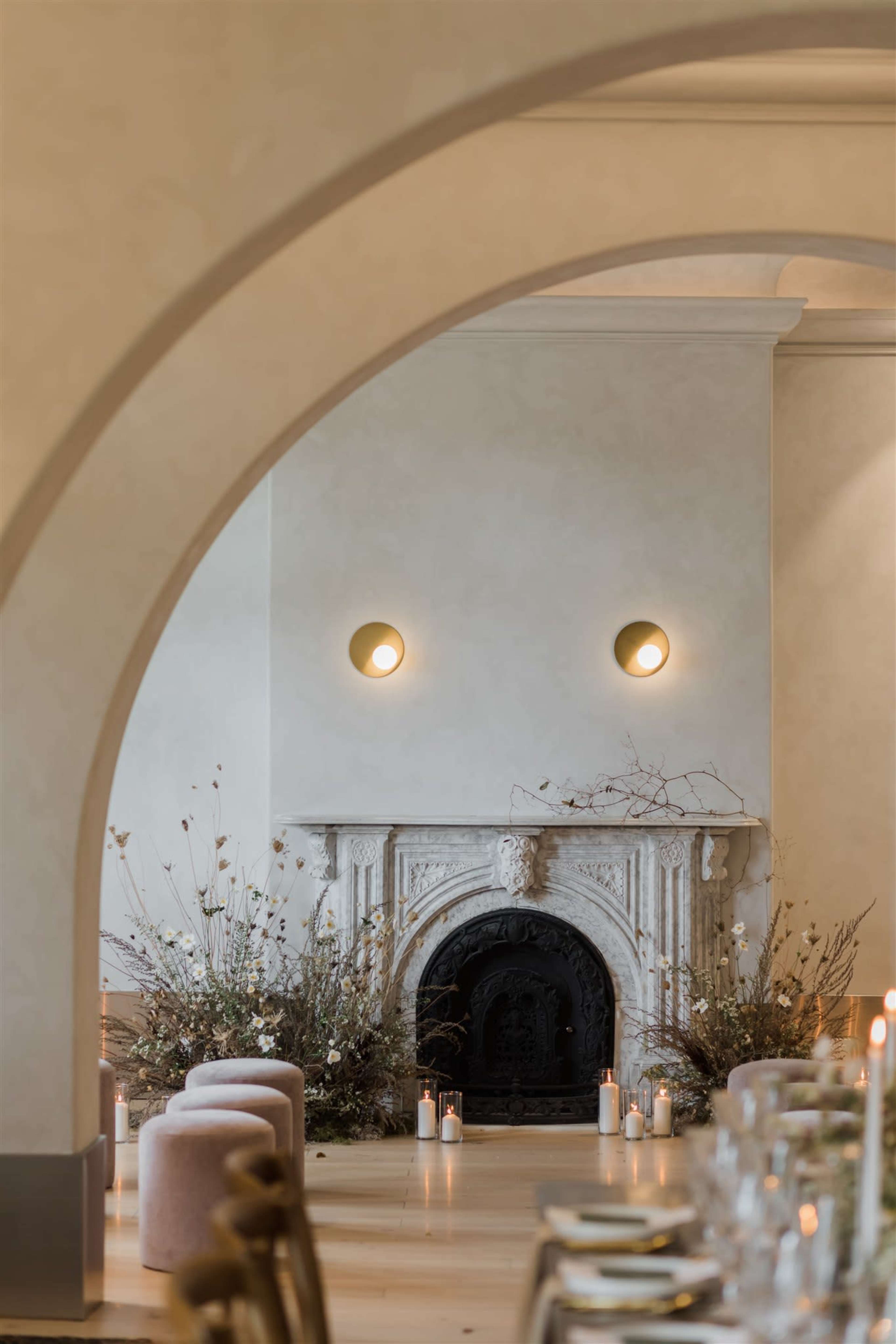 A beautifully styled dining area features a stone fireplace adorned with floral arrangements and candles.