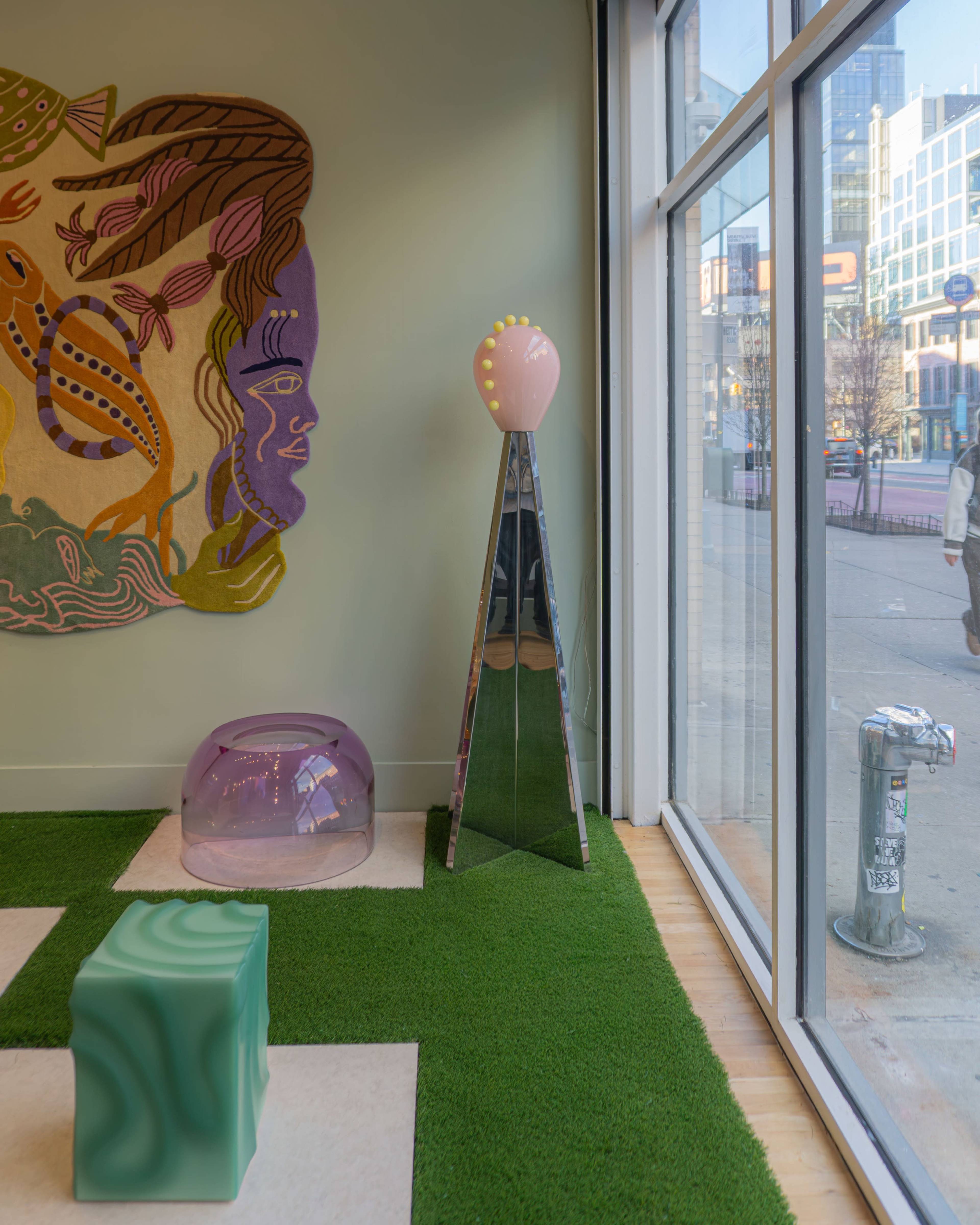 The scene features a bright interior with a decorative wall mural, colorful furniture pieces, and a large window providing street visibility.