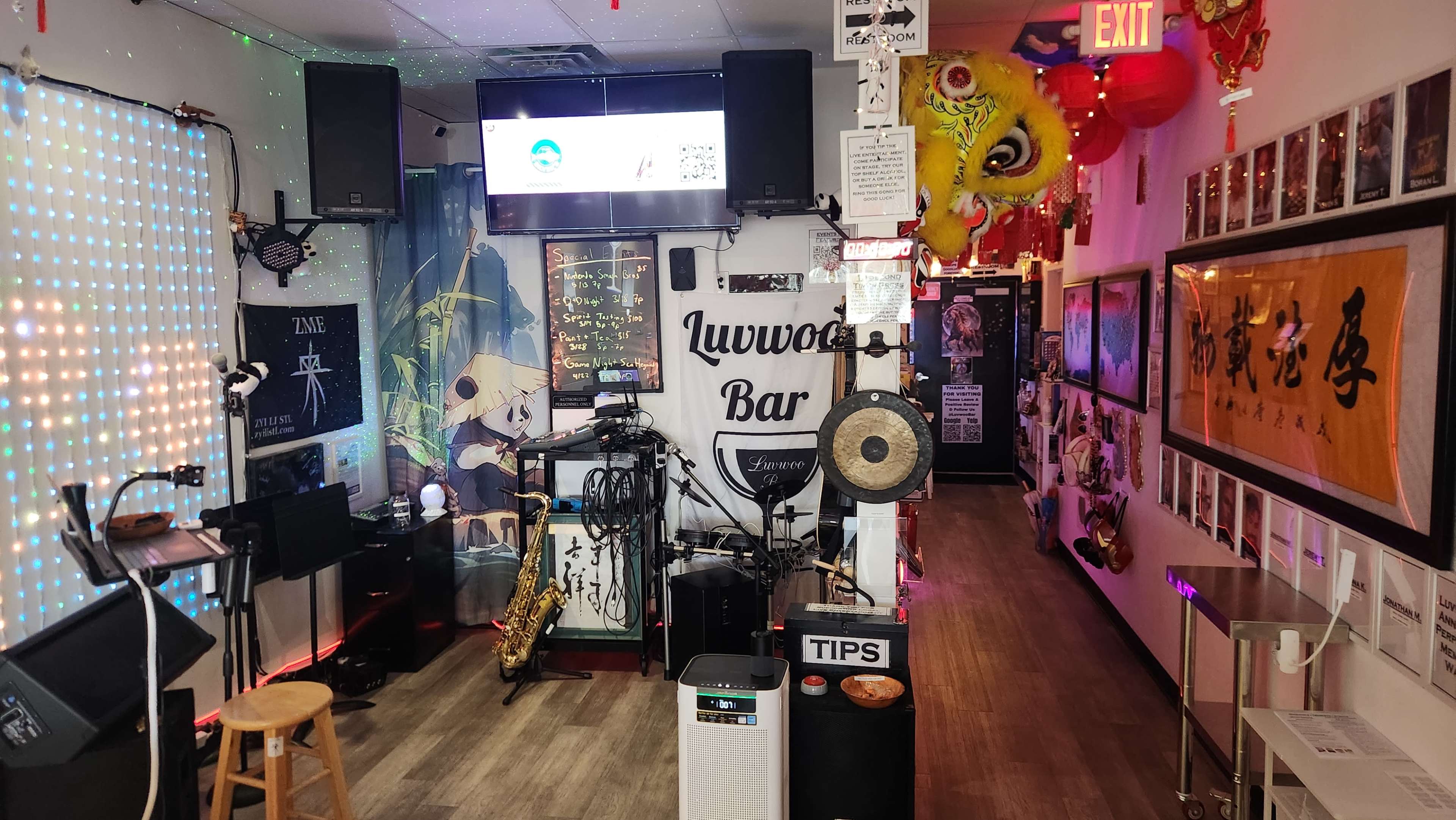 The image shows the interior of a bar featuring musical equipment, decorative hanging ornaments, and various framed artworks on the walls.