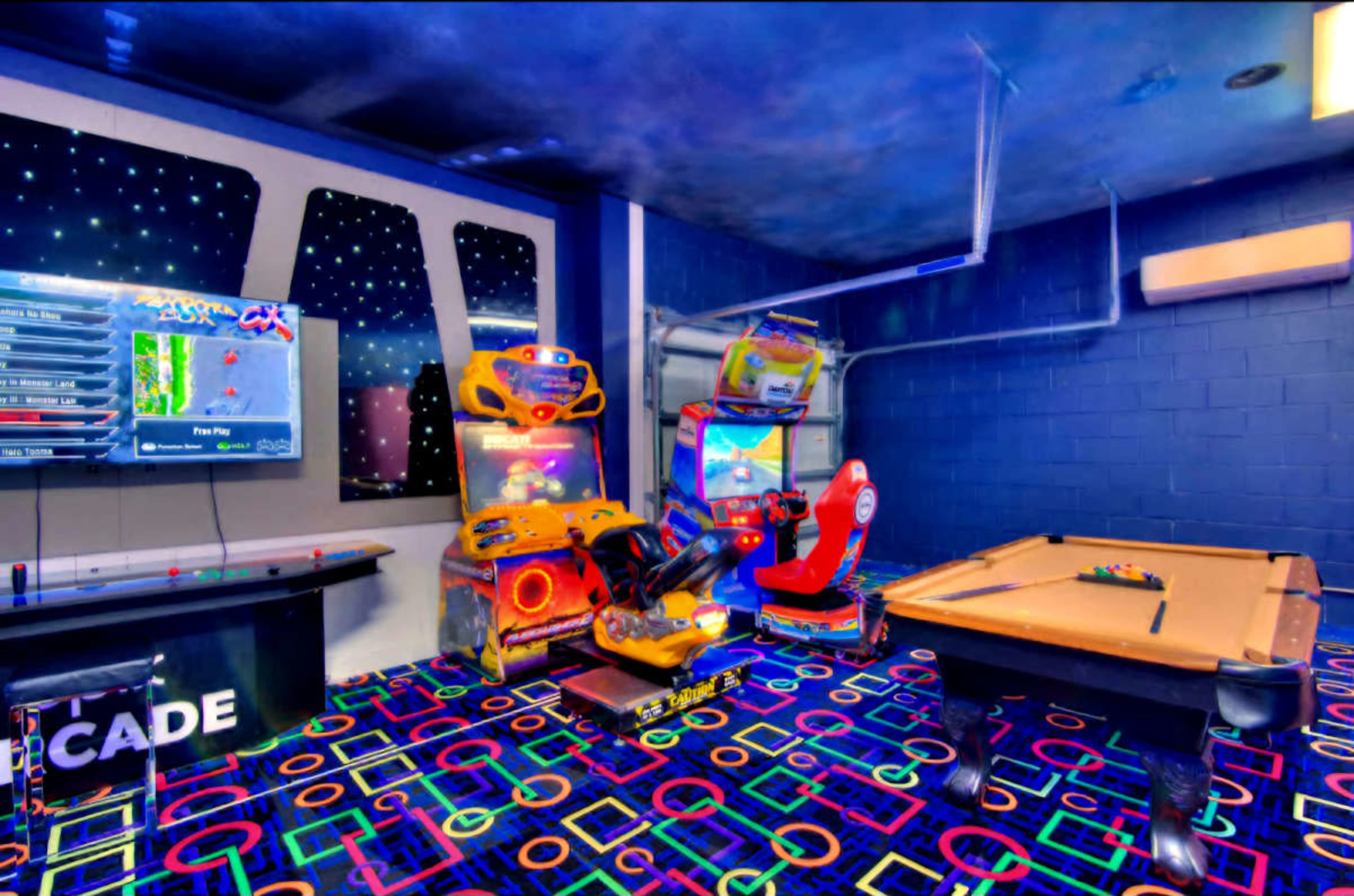 The image shows a game room with arcade machines, a pool table, and colorful geometric patterns on the floor.