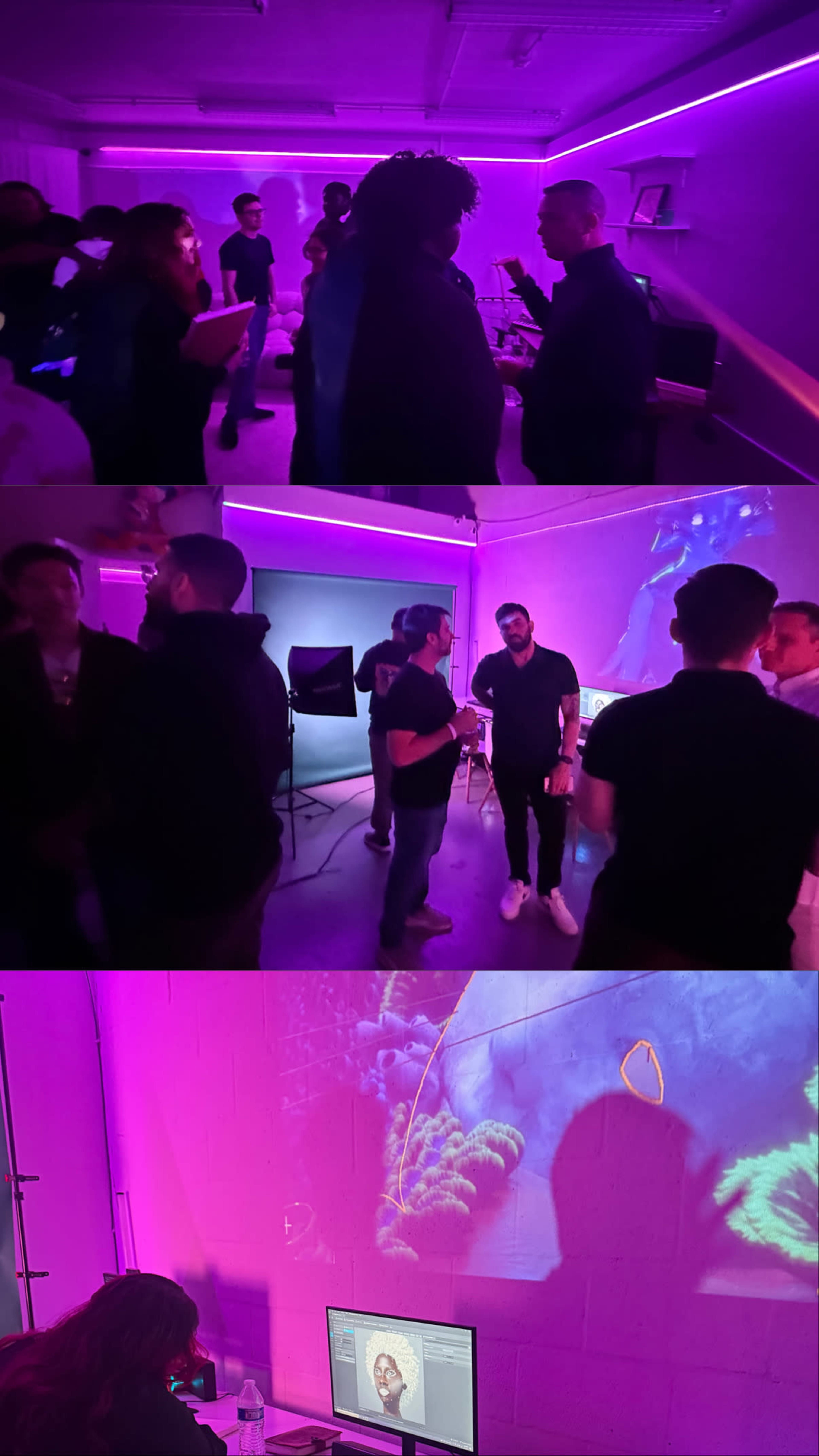 A group of people is gathered in a dimly lit room with purple lighting, engaging in conversation while a projection of underwater scenes is displayed on the wall.