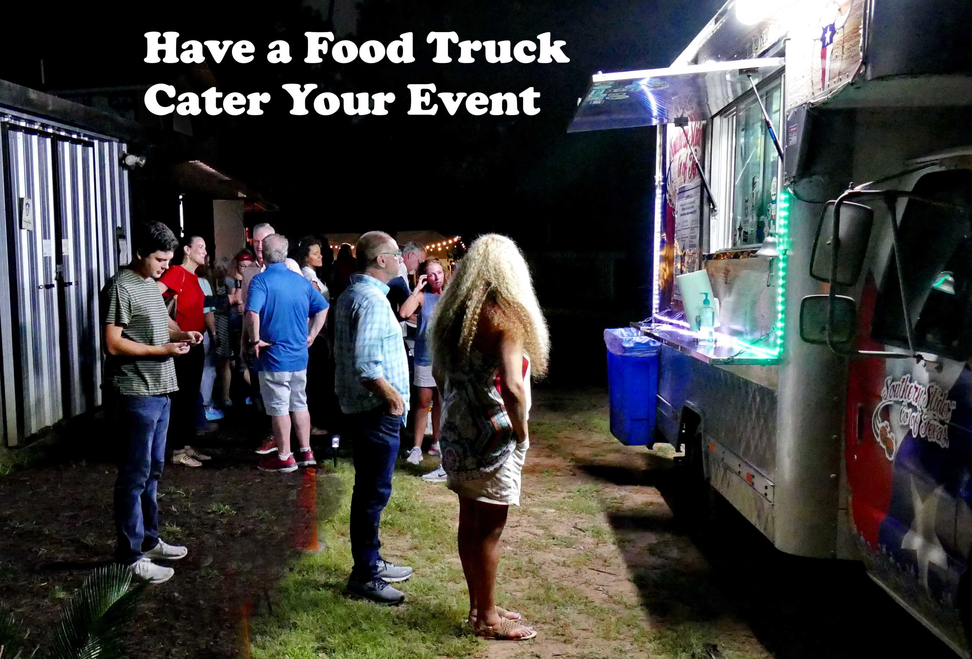 A group of people stands in line at a food truck under evening lights.