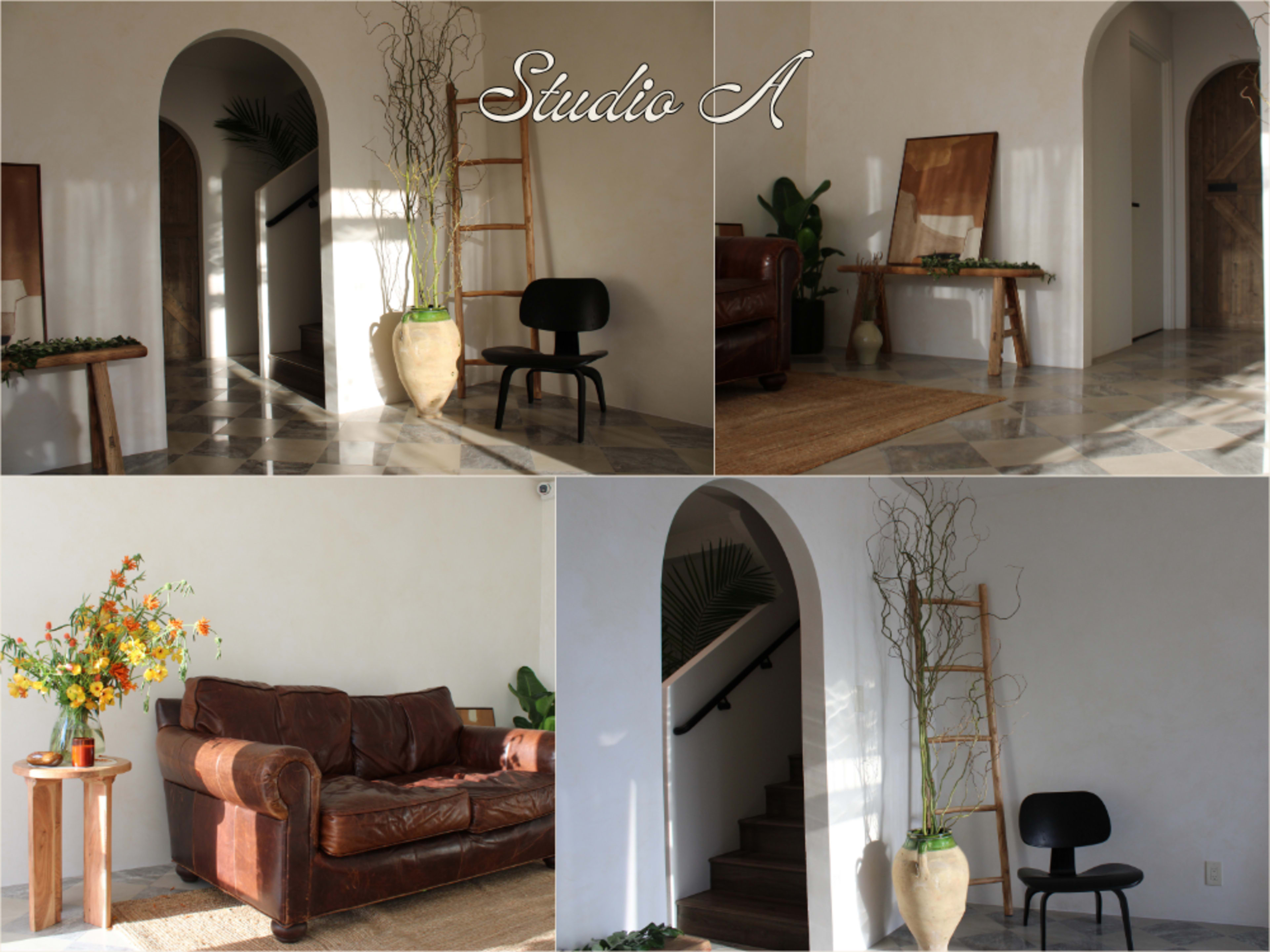 The image showcases a well-lit interior space featuring a brown leather sofa, a black chair, a wooden ladder, and decorative elements like a vase with flowers and a potted plant.