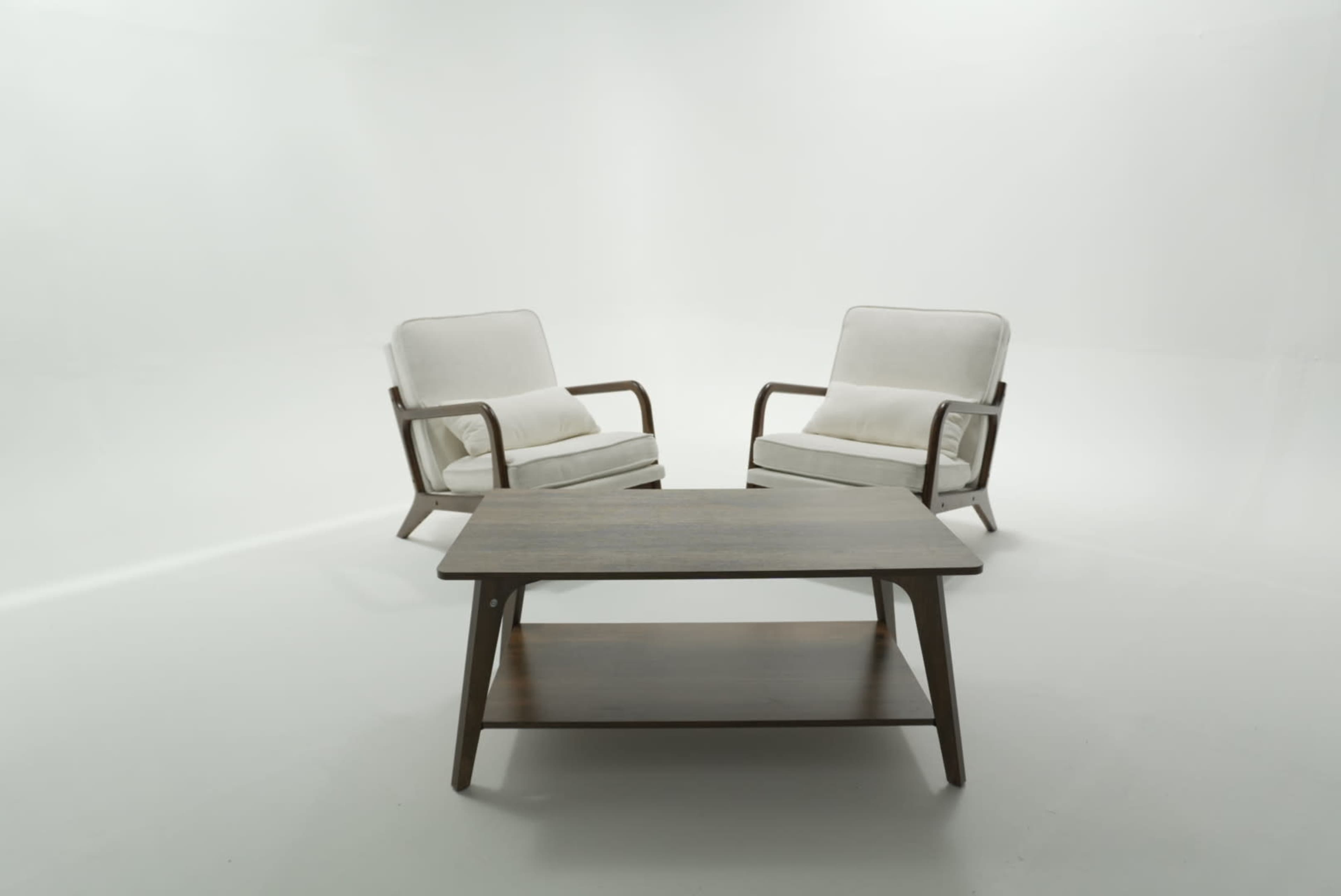 The image shows a minimalistic setup featuring two white upholstered armchairs and a wooden coffee table on a white backdrop.