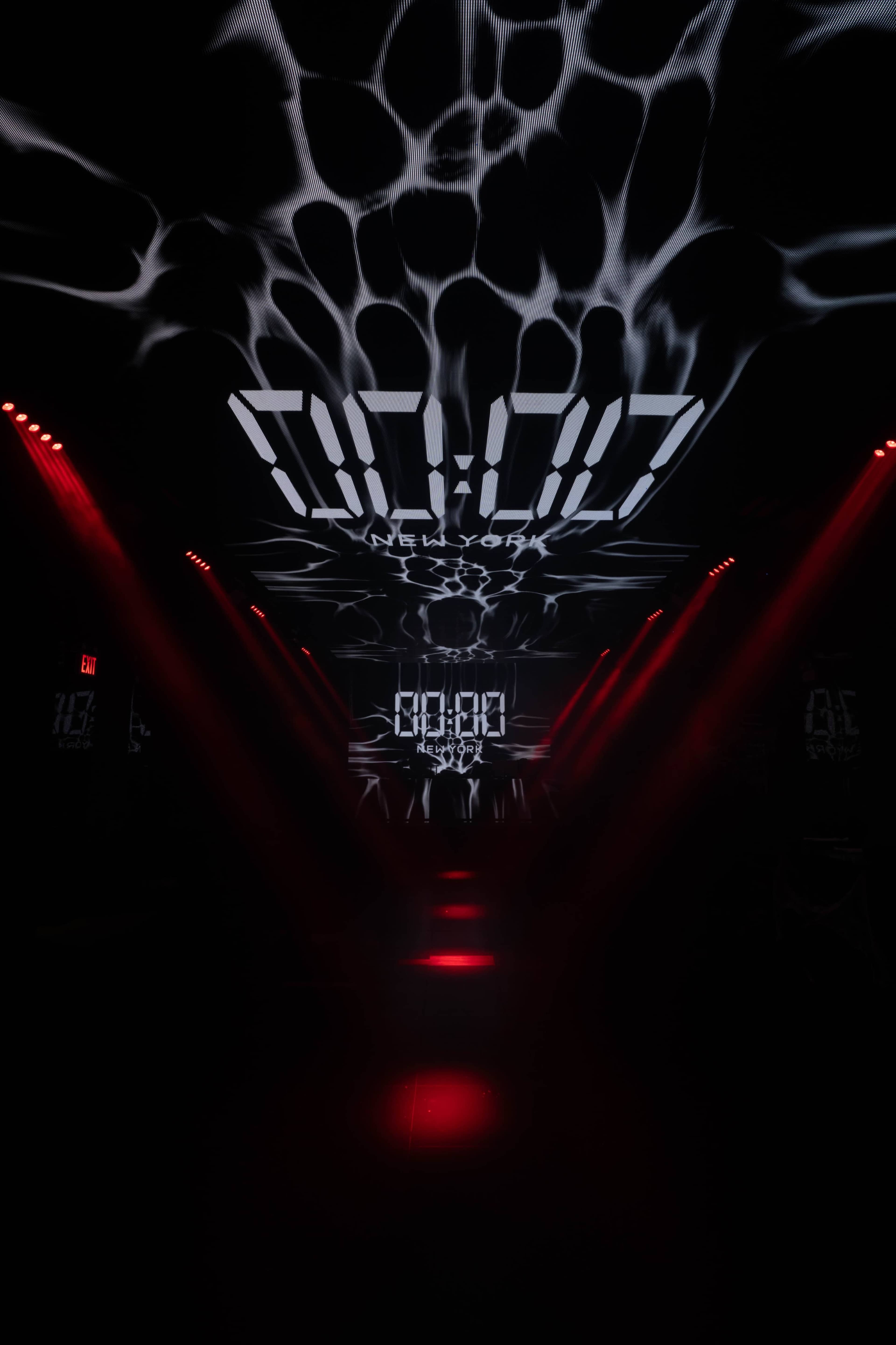 The image shows a dark corridor illuminated by red lights, with a digital timer displayed prominently on the ceiling and water-like patterns projected on the walls.