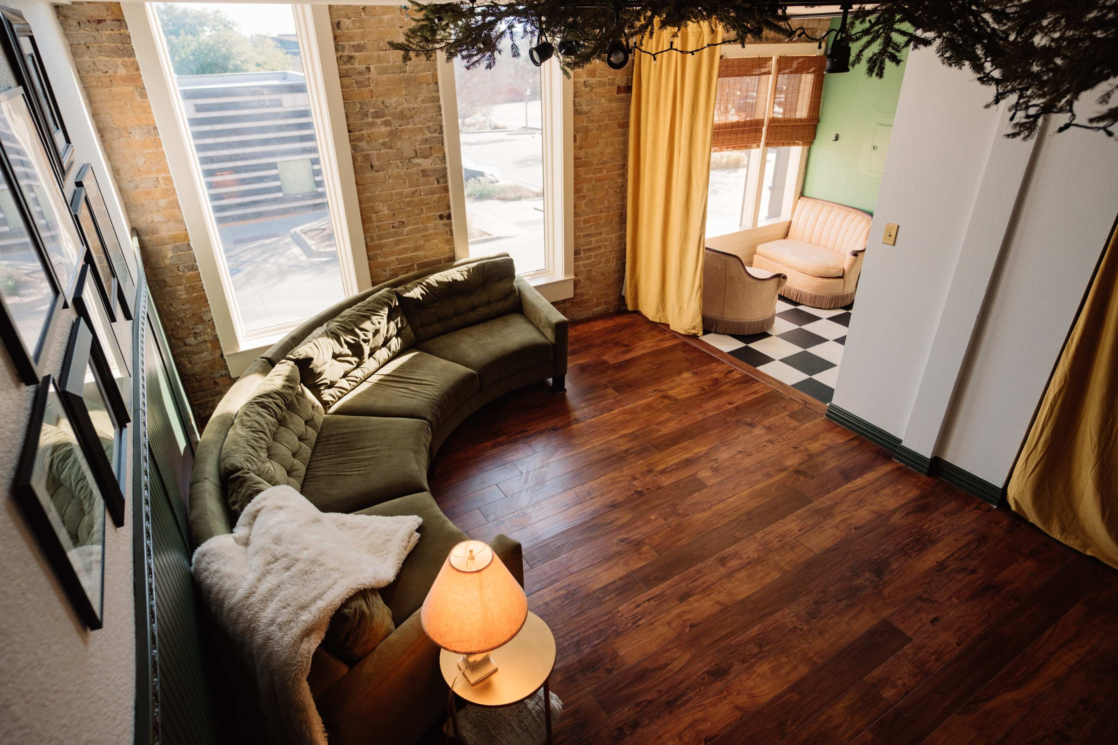 Mid-Century Modern European Inspired Living Room Loft - with exposed brick, large windows for natural light, and access to a full kitchen & bathroom Image in Denton, Denton, TX