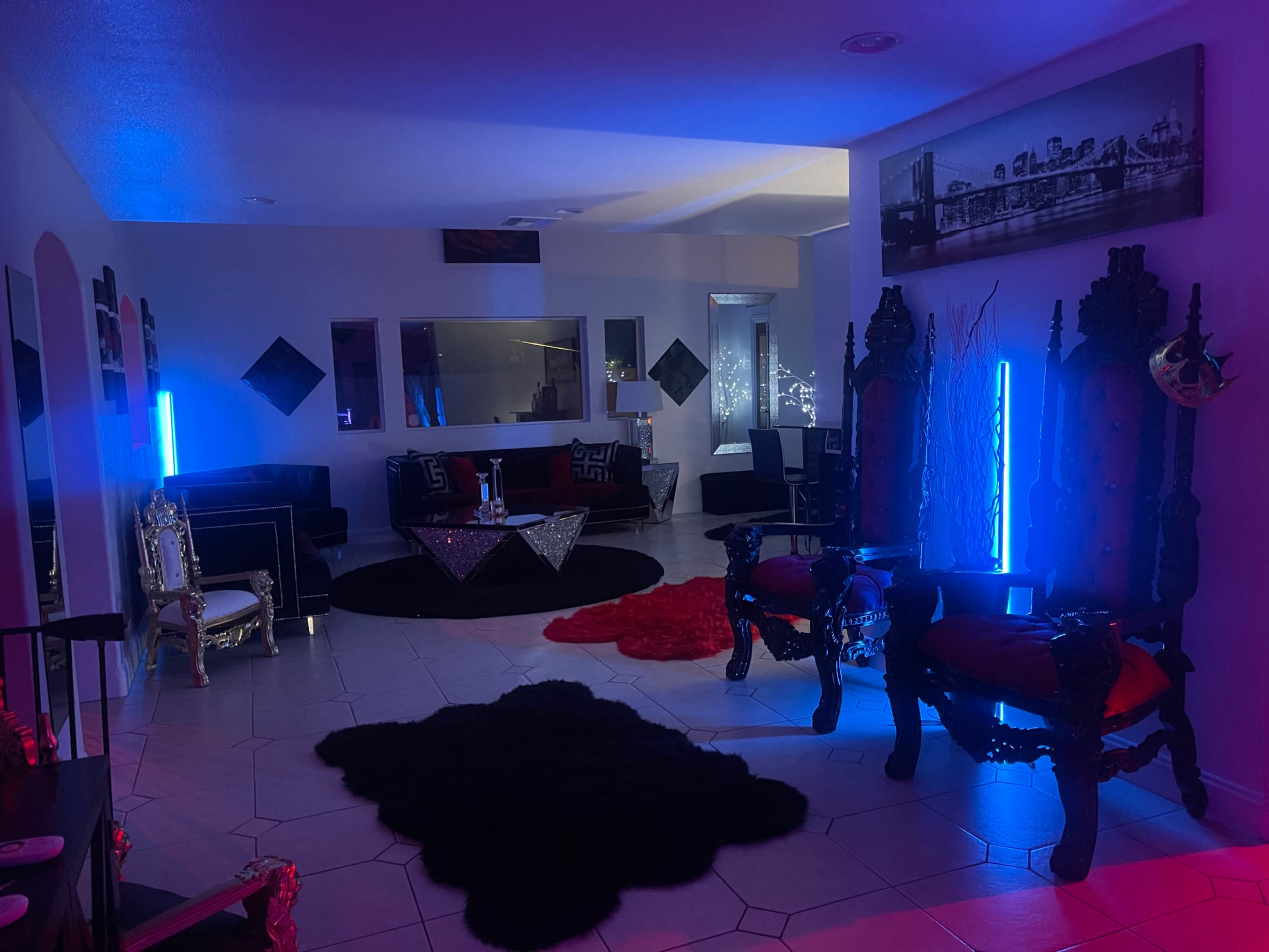 The room features two ornate throne chairs, a low table with a tablecloth, and colorful lighting creating an ambient atmosphere.