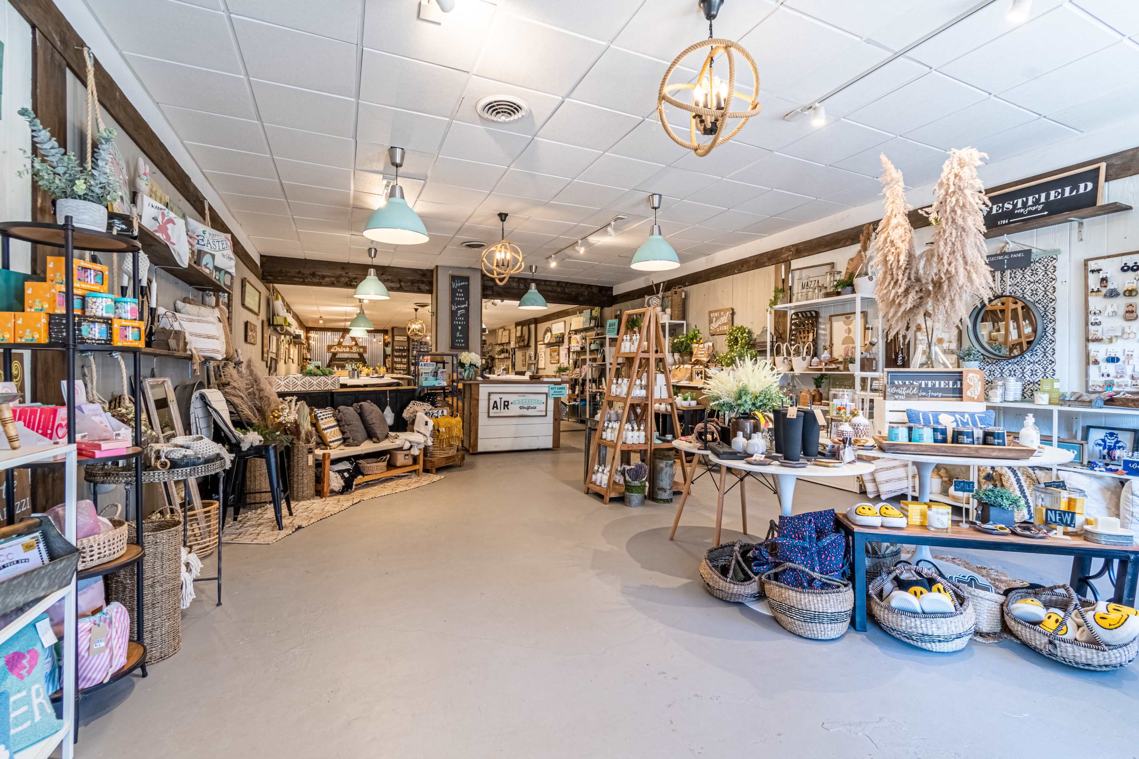A brightly lit boutique with various home decor items and furniture arranged throughout the space.