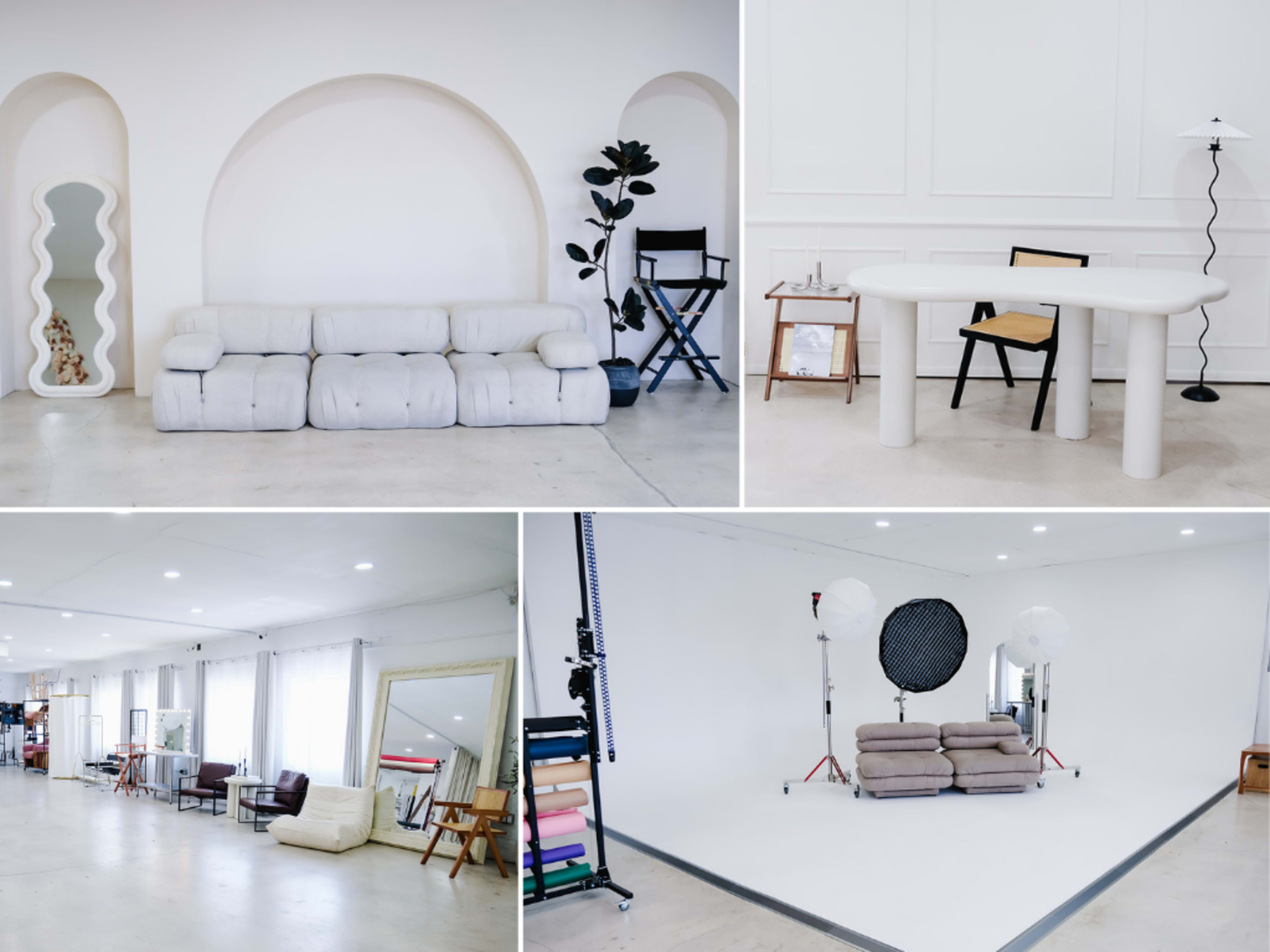 The image features a modern studio space divided into different areas, including a minimalist living area with a white couch, a workspace with a round table and chairs, and an empty backdrop section with lighting equipment.