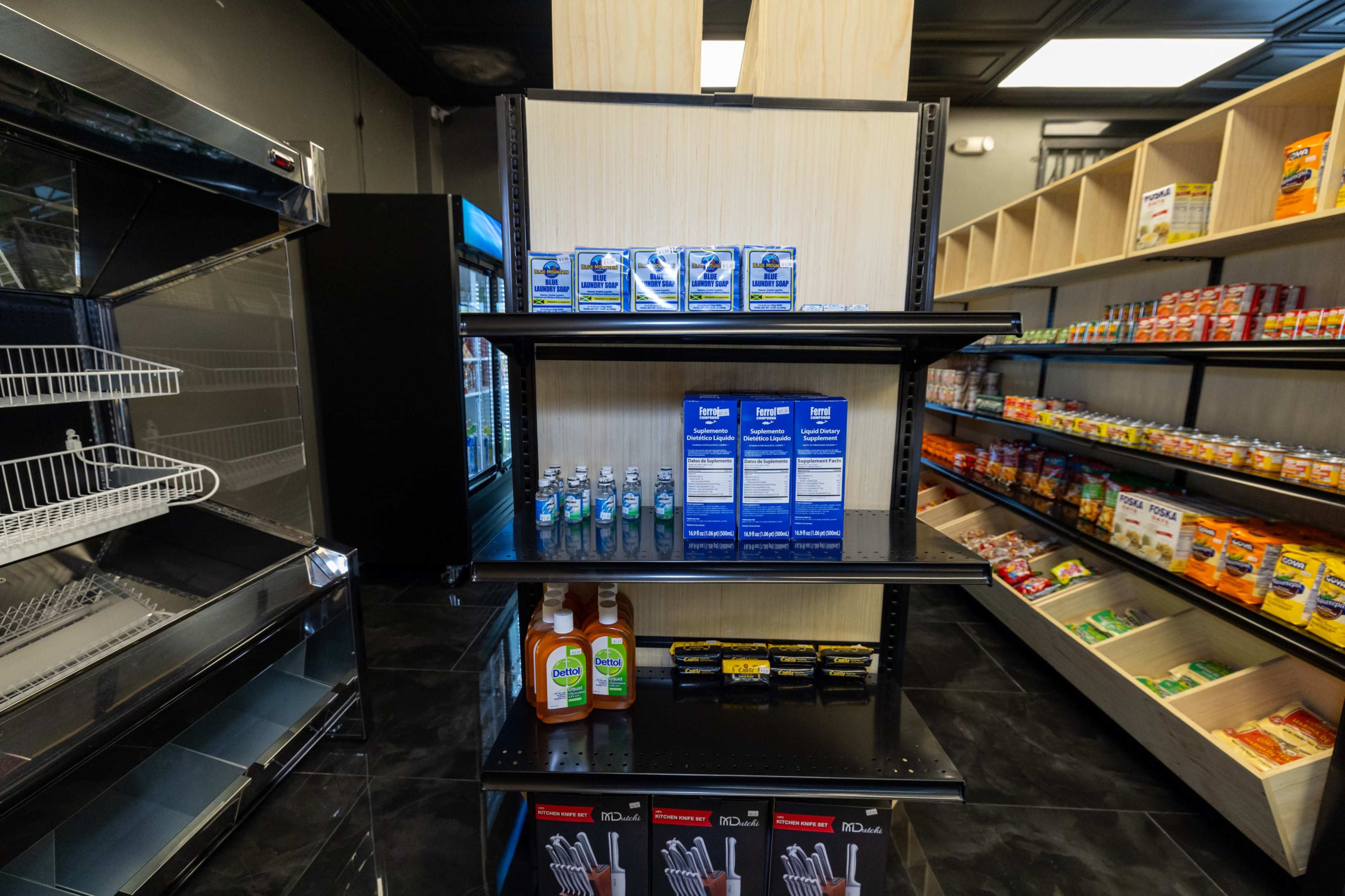 The image shows a grocery store interior with shelves displaying various packaged food items and beverages, along with a cooling section on the left.