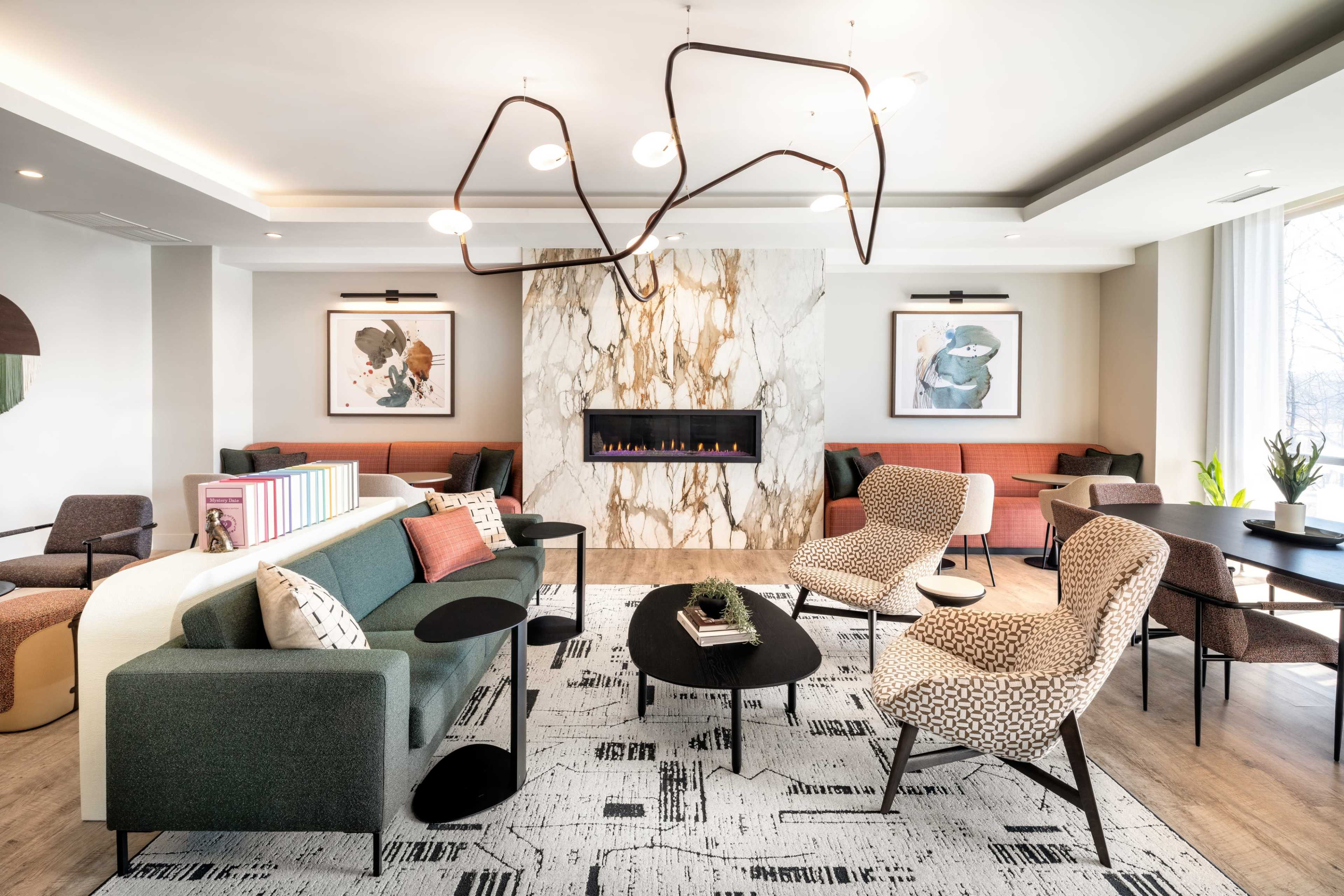 The image depicts a modern living space with a marble fireplace, stylish seating arrangements, and large artworks on the walls.