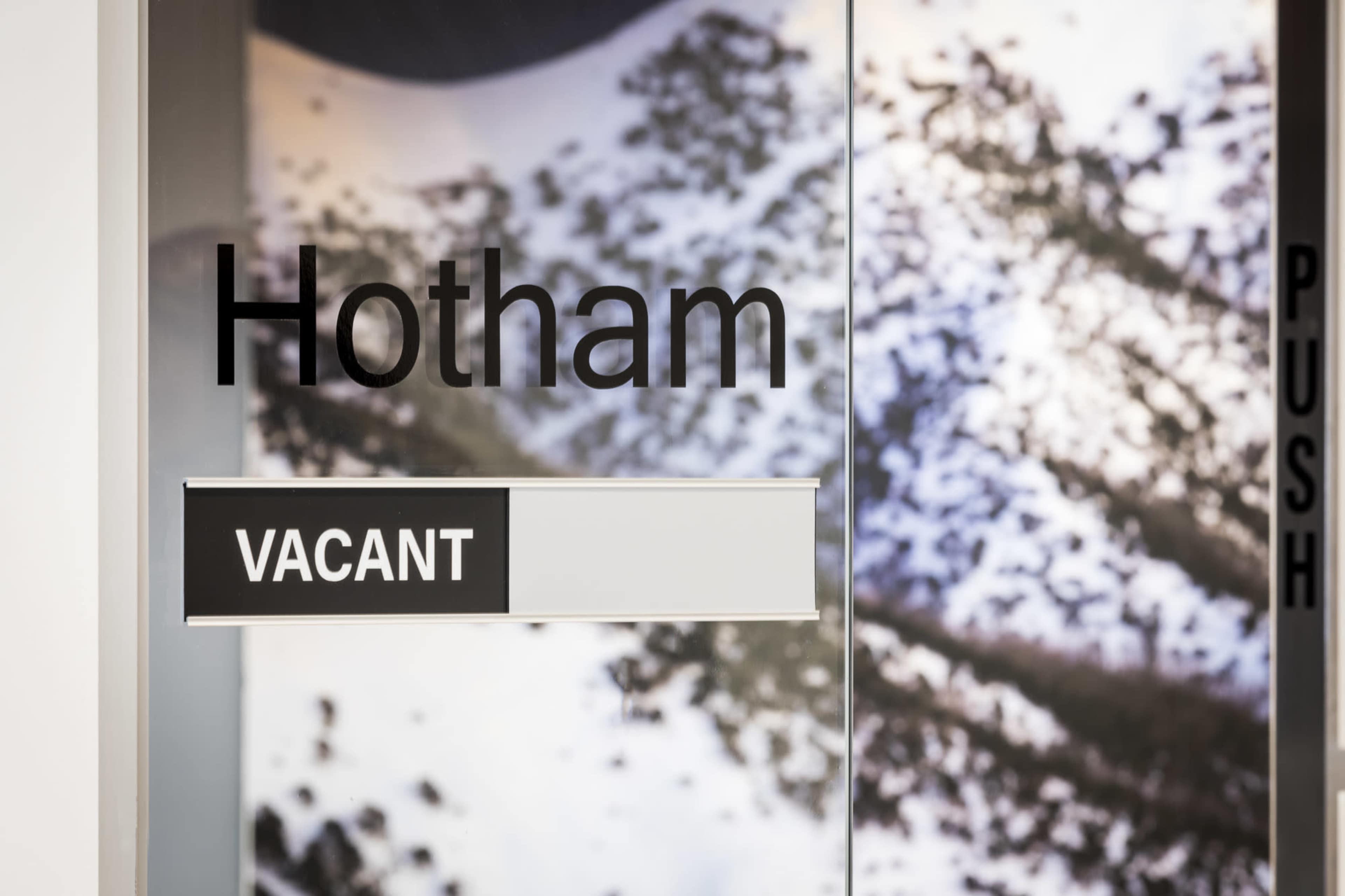 A door sign displays the name "Hotham" above the word "VACANT."