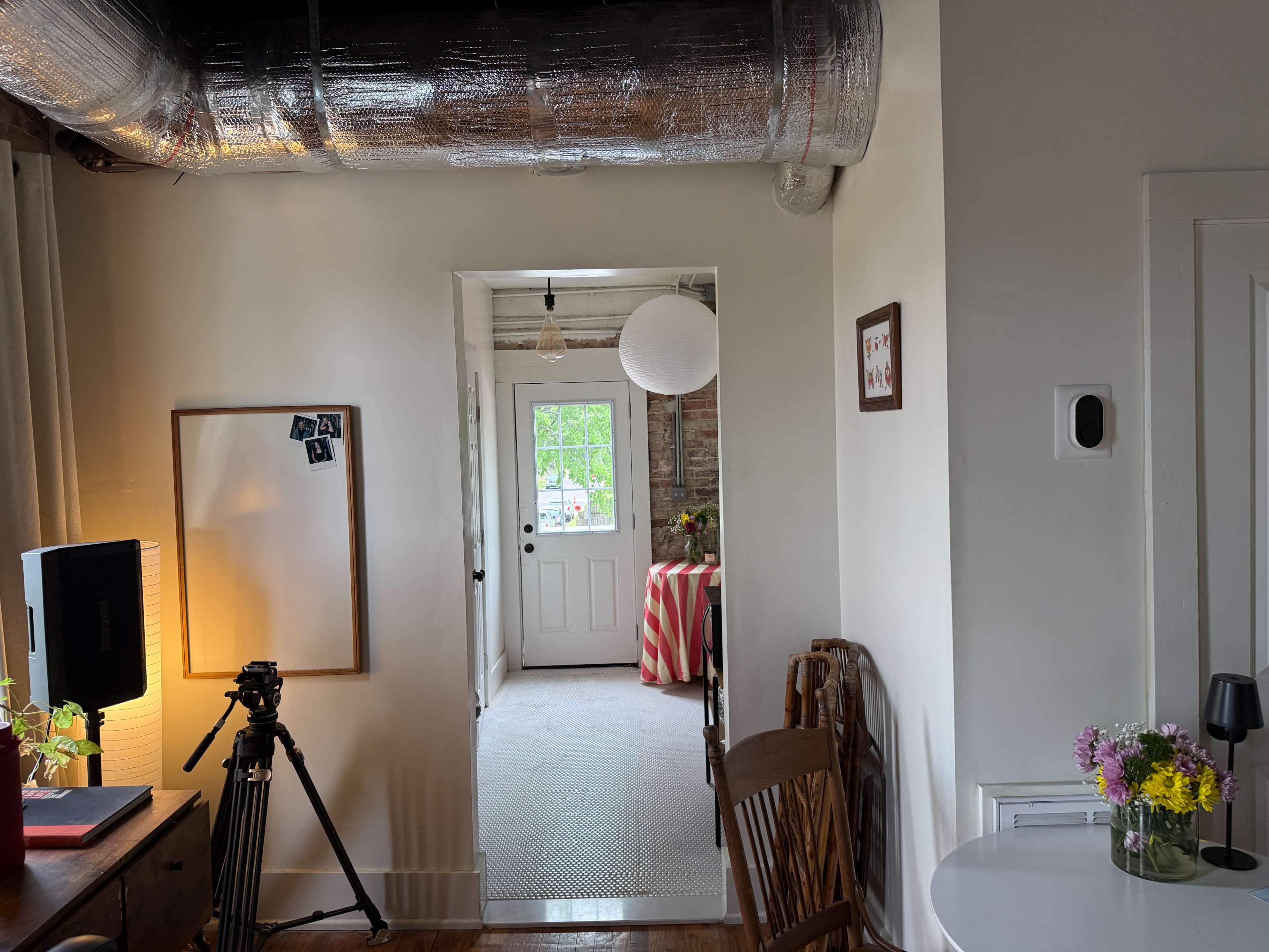 The image shows a room with a doorway leading to another area, featuring a door, a striped tablecloth on a table, and various decorations.