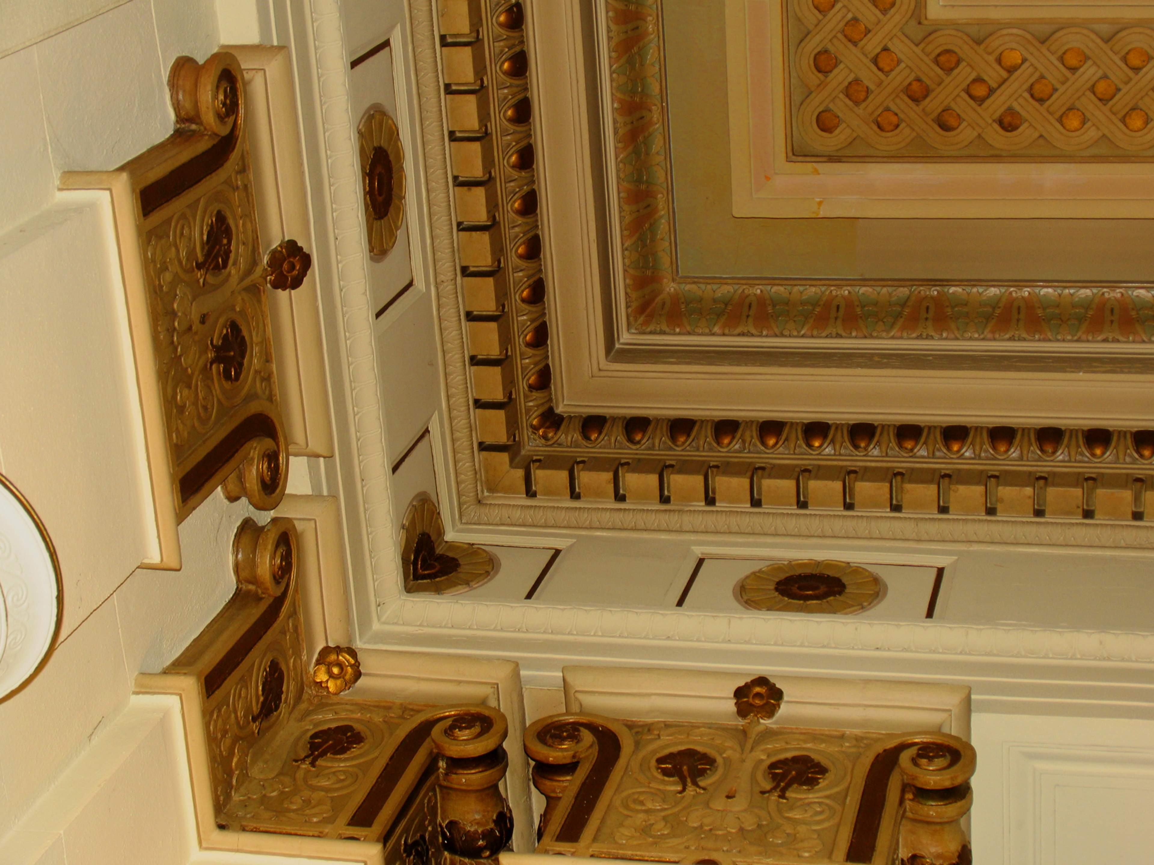 An ornate ceiling with intricately designed moldings and decorative patterns.