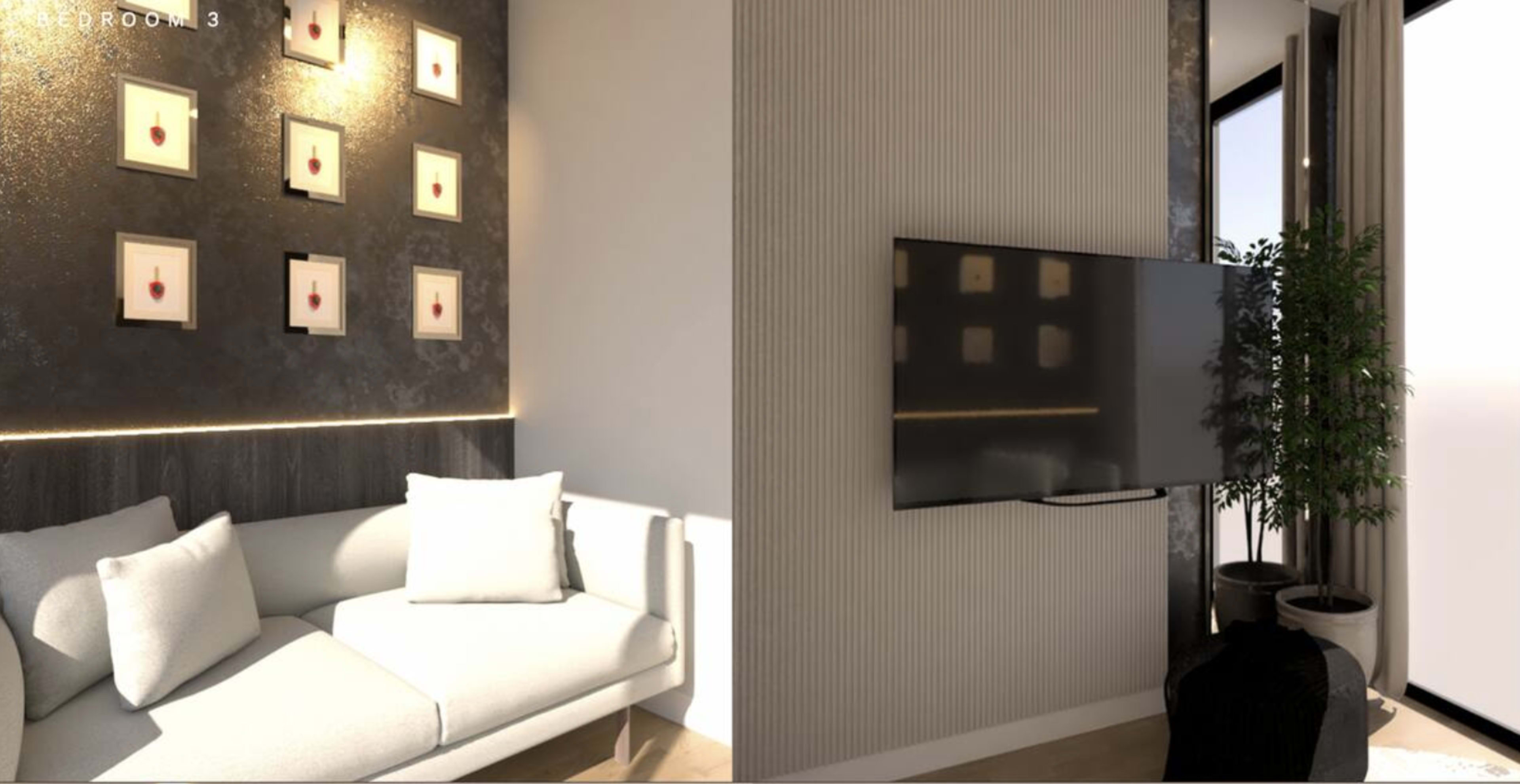 The image shows a modern interior space featuring a light-colored sofa adjacent to a wall with framed artwork, and a flat-screen television mounted on a textured wall with a potted plant nearby.