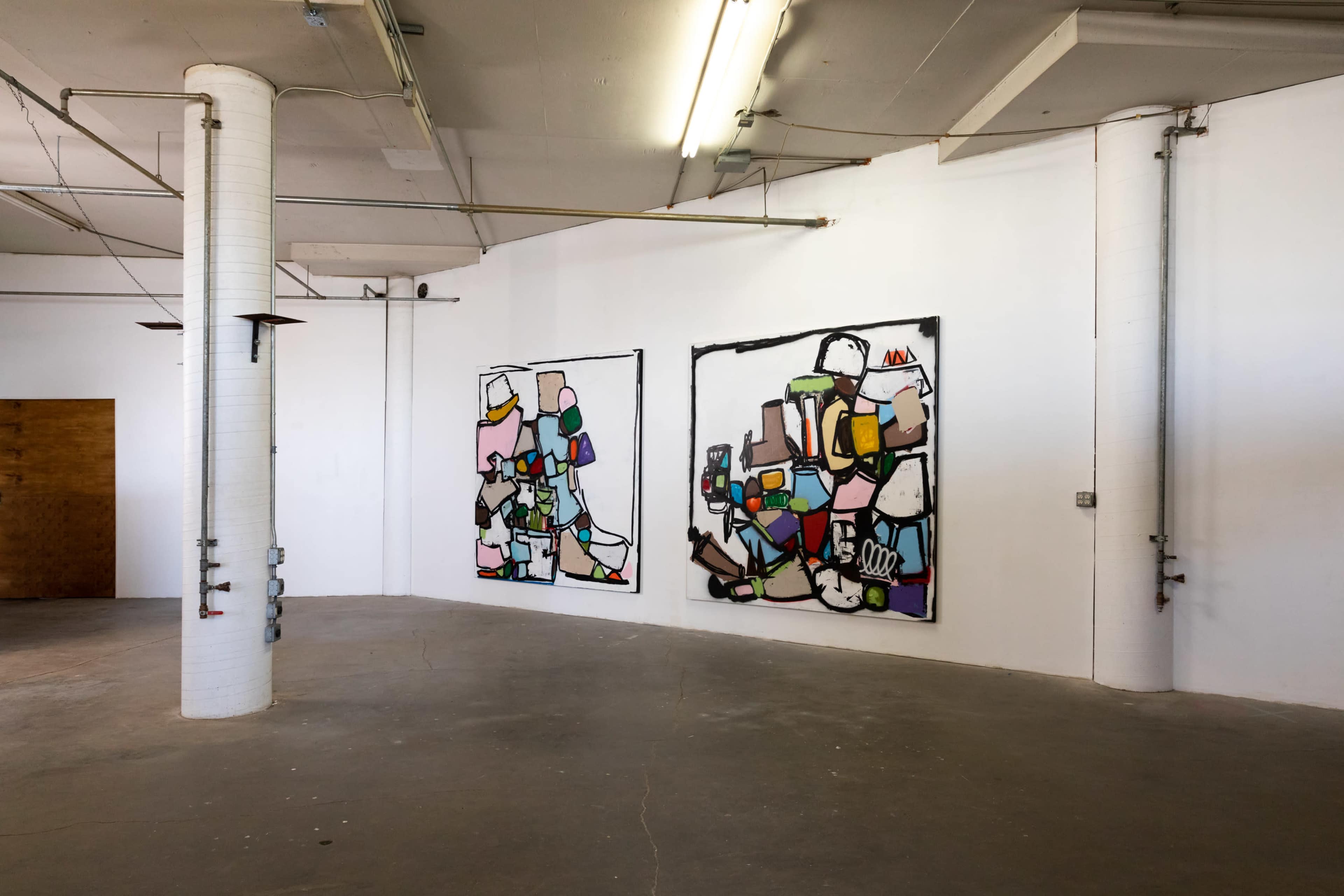 A spacious gallery with two large abstract paintings hanging on a white wall.