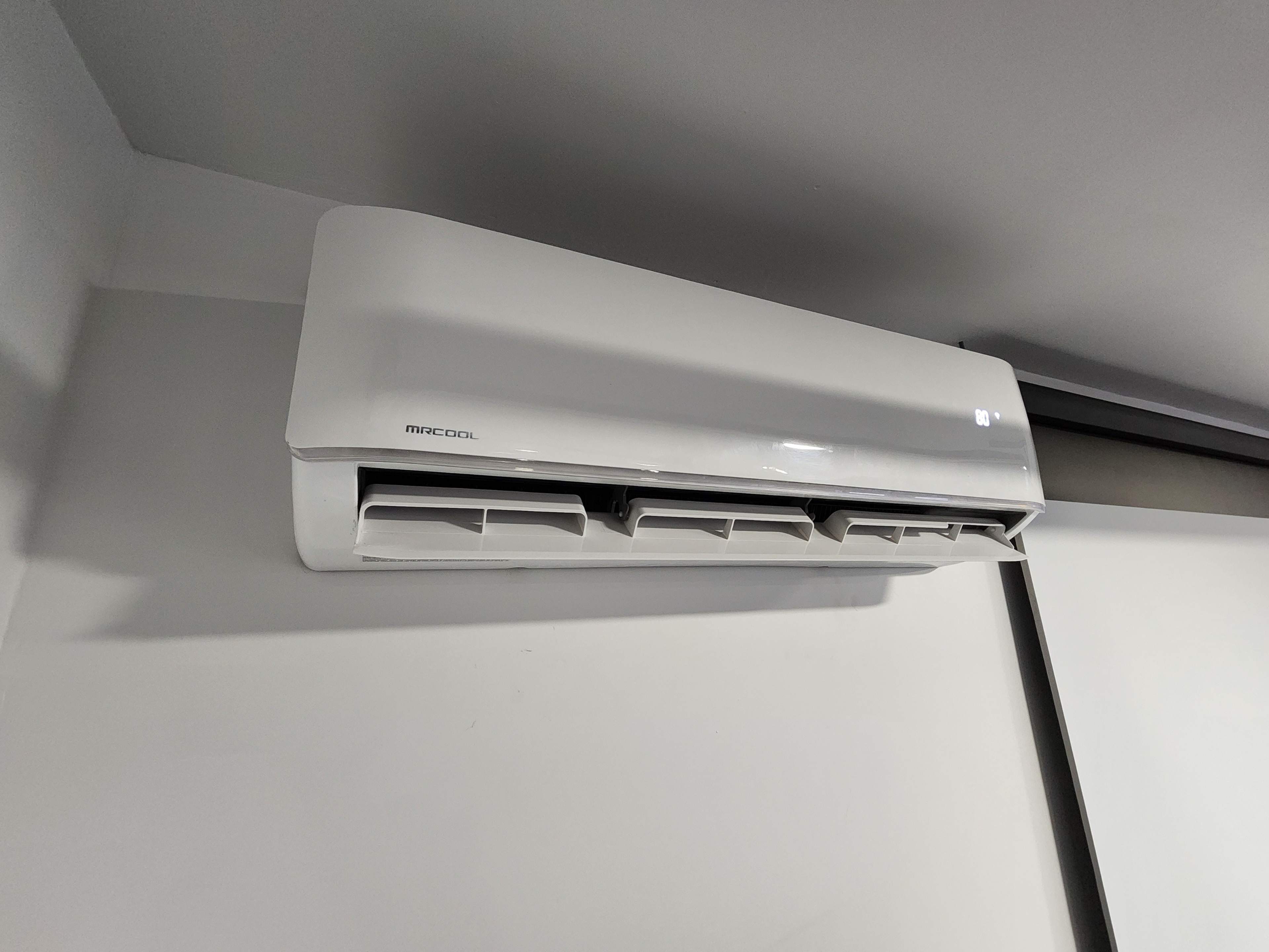A white split-type air conditioning unit mounted on a wall.