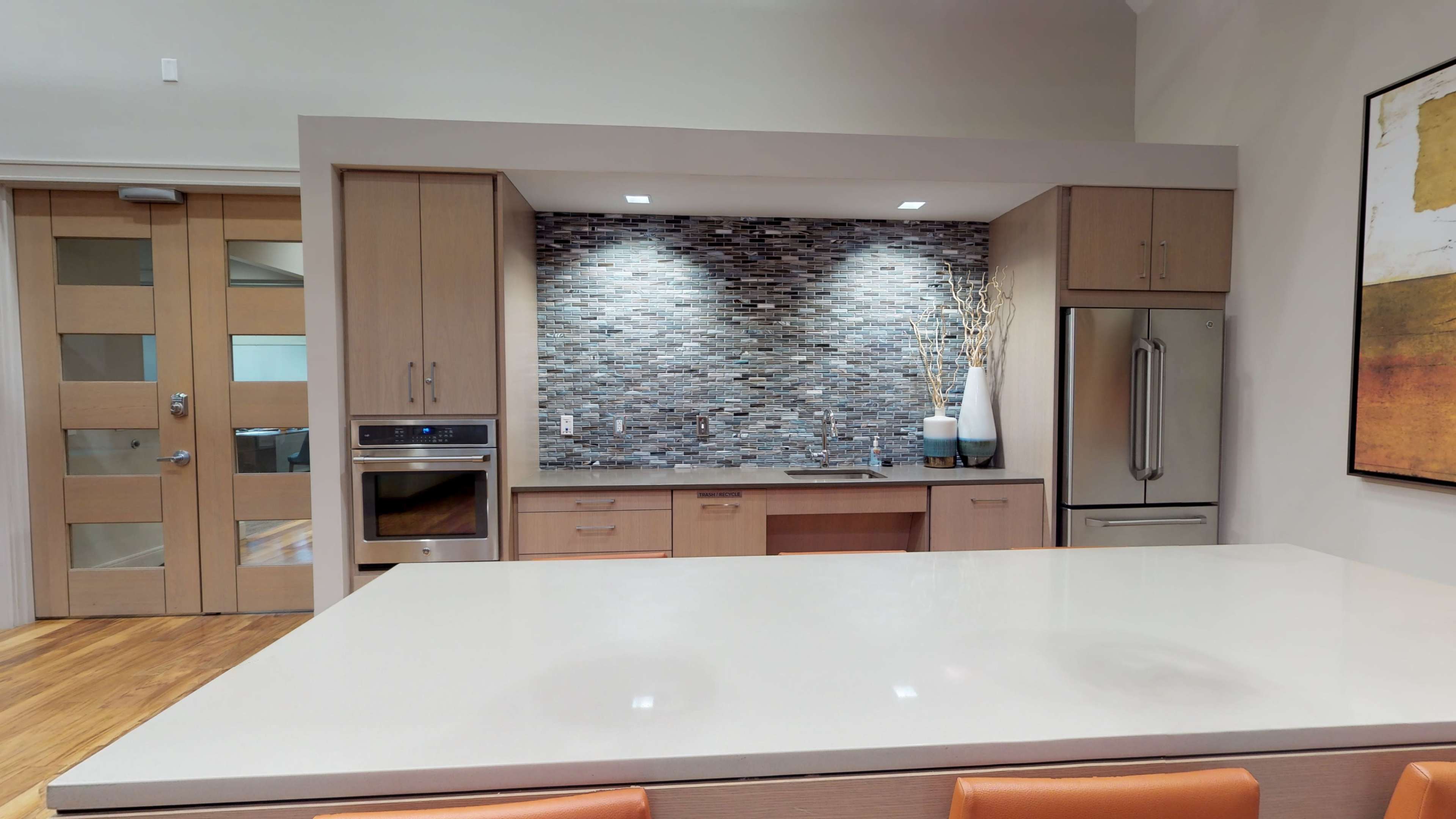 The kitchen features a modern design with a large island, sleek cabinetry, and a tiled backsplash.