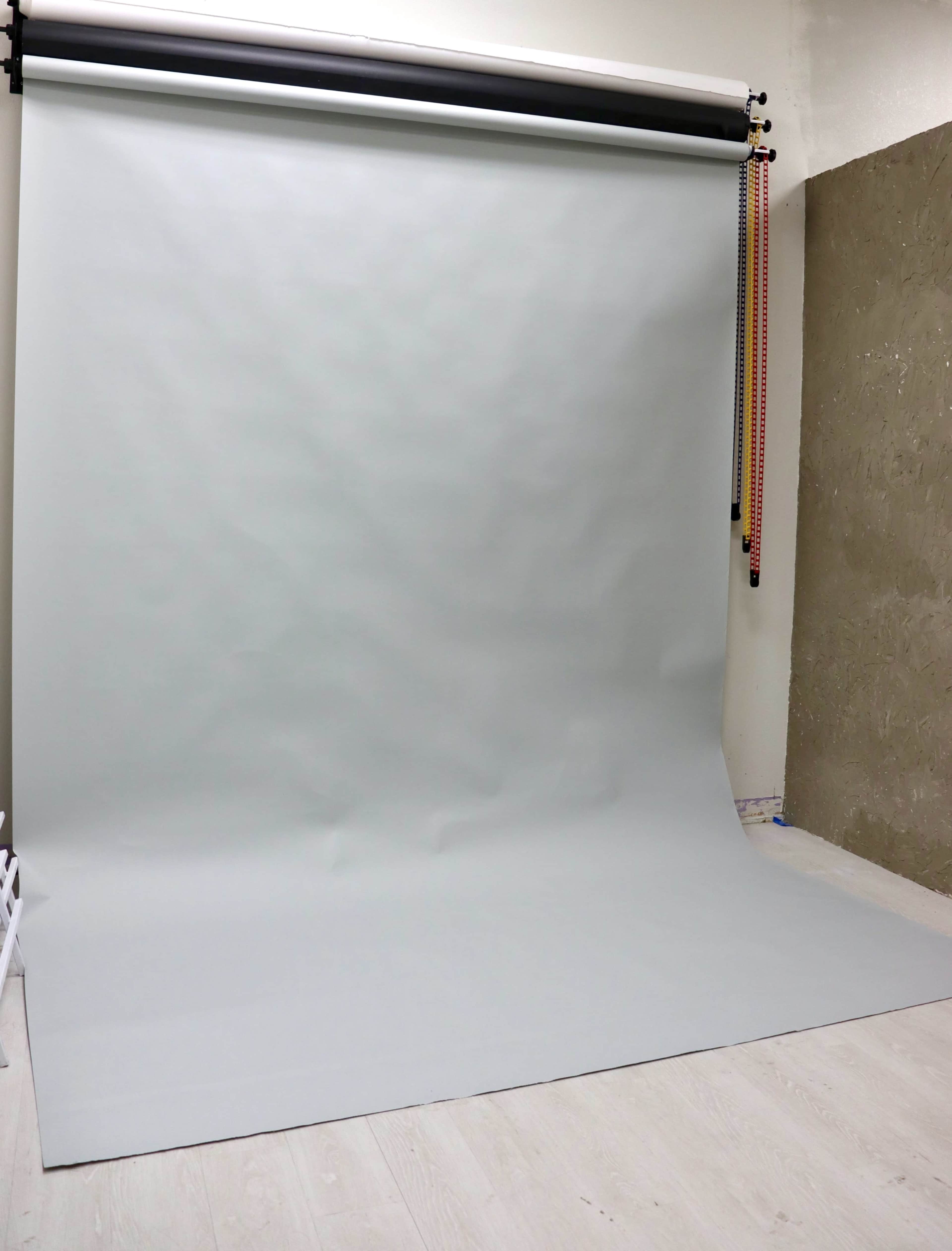 A photography studio with a gray backdrop stretched from a support system onto the floor.