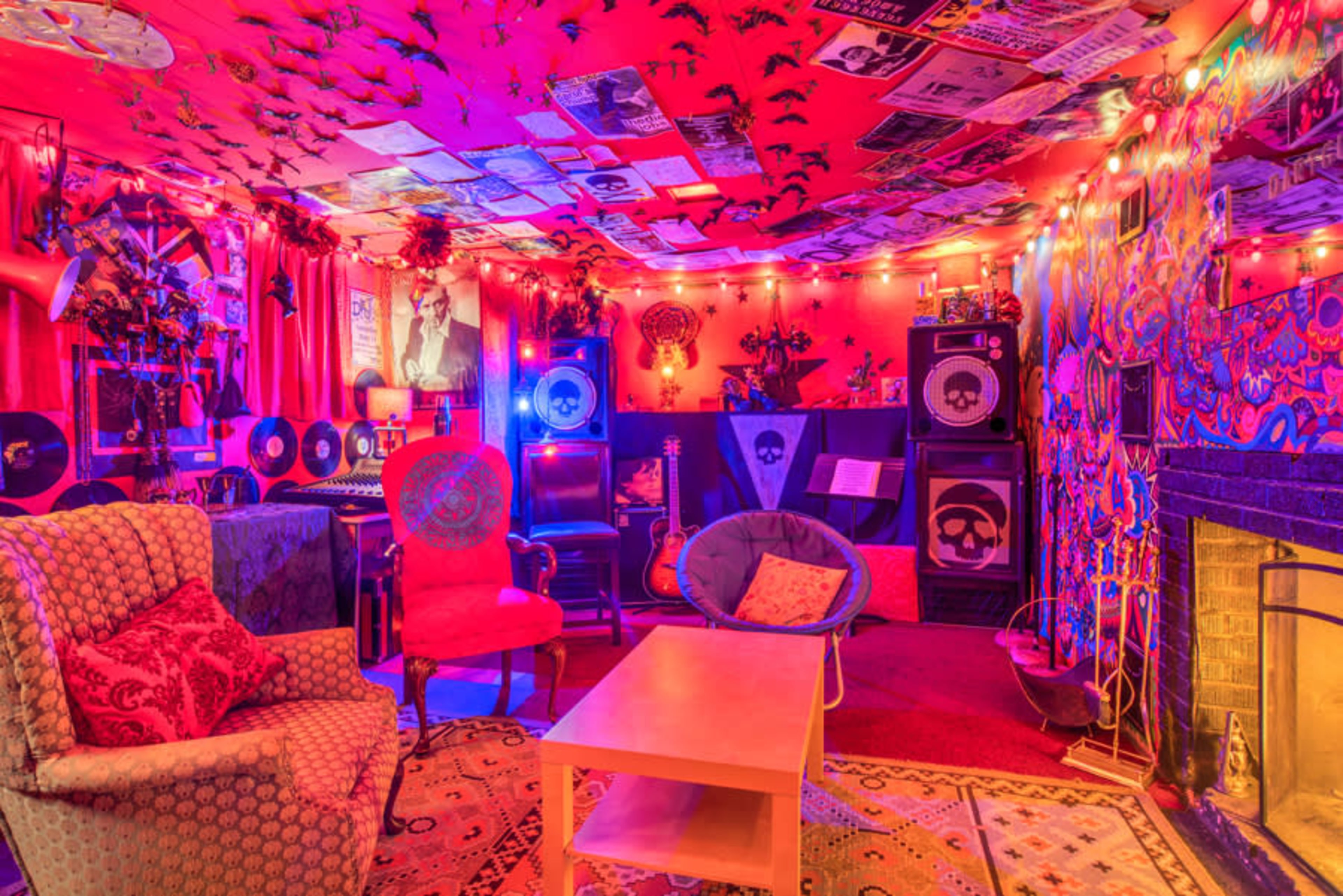 A vibrant and eclectic room with colorful walls, vintage music decor, a fireplace, and various seating arrangements.