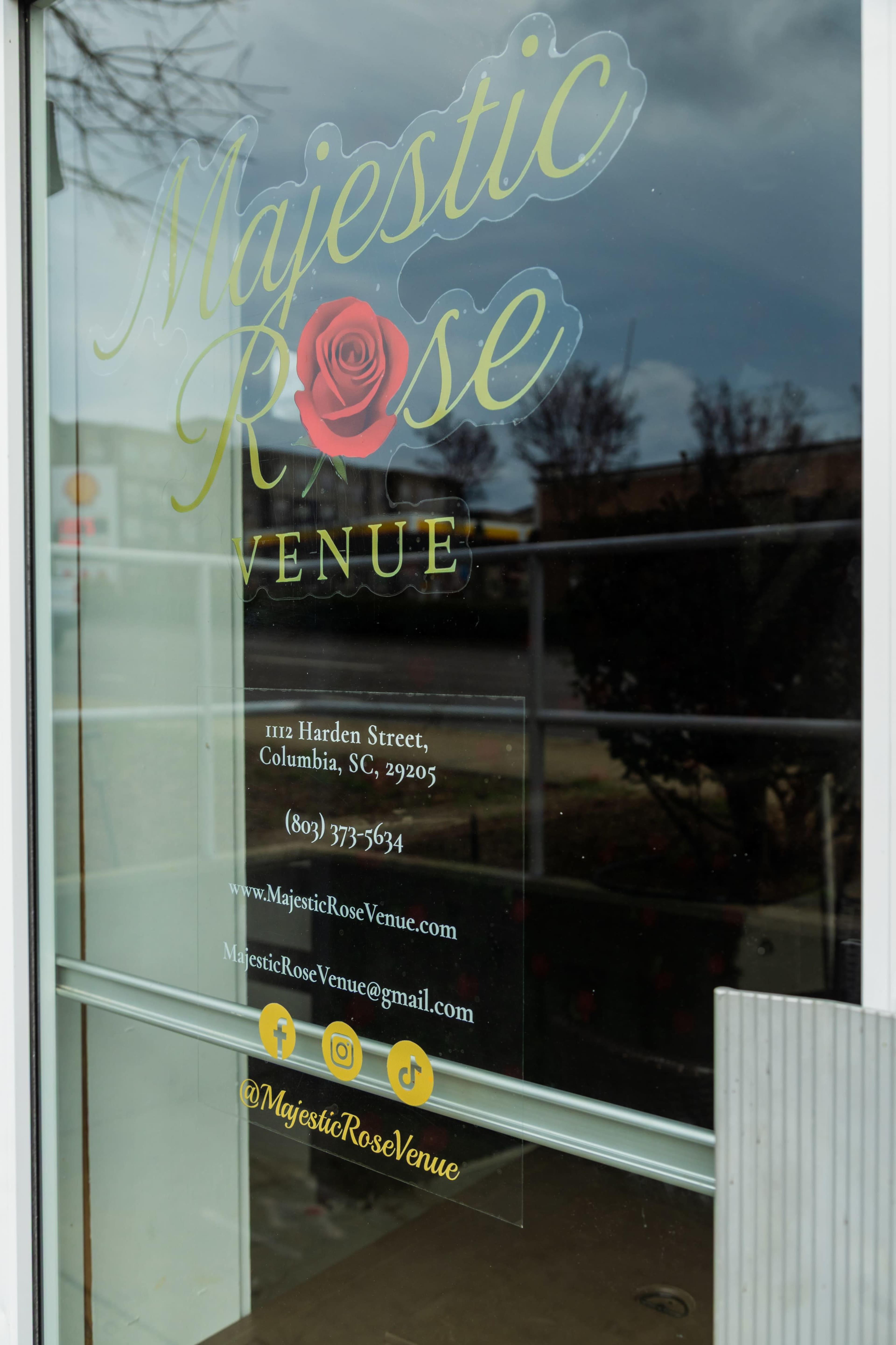 The image shows a window display featuring the logo and contact information for "Majestic Rose Venue" located at 1112 Harden Street, Columbia, SC.