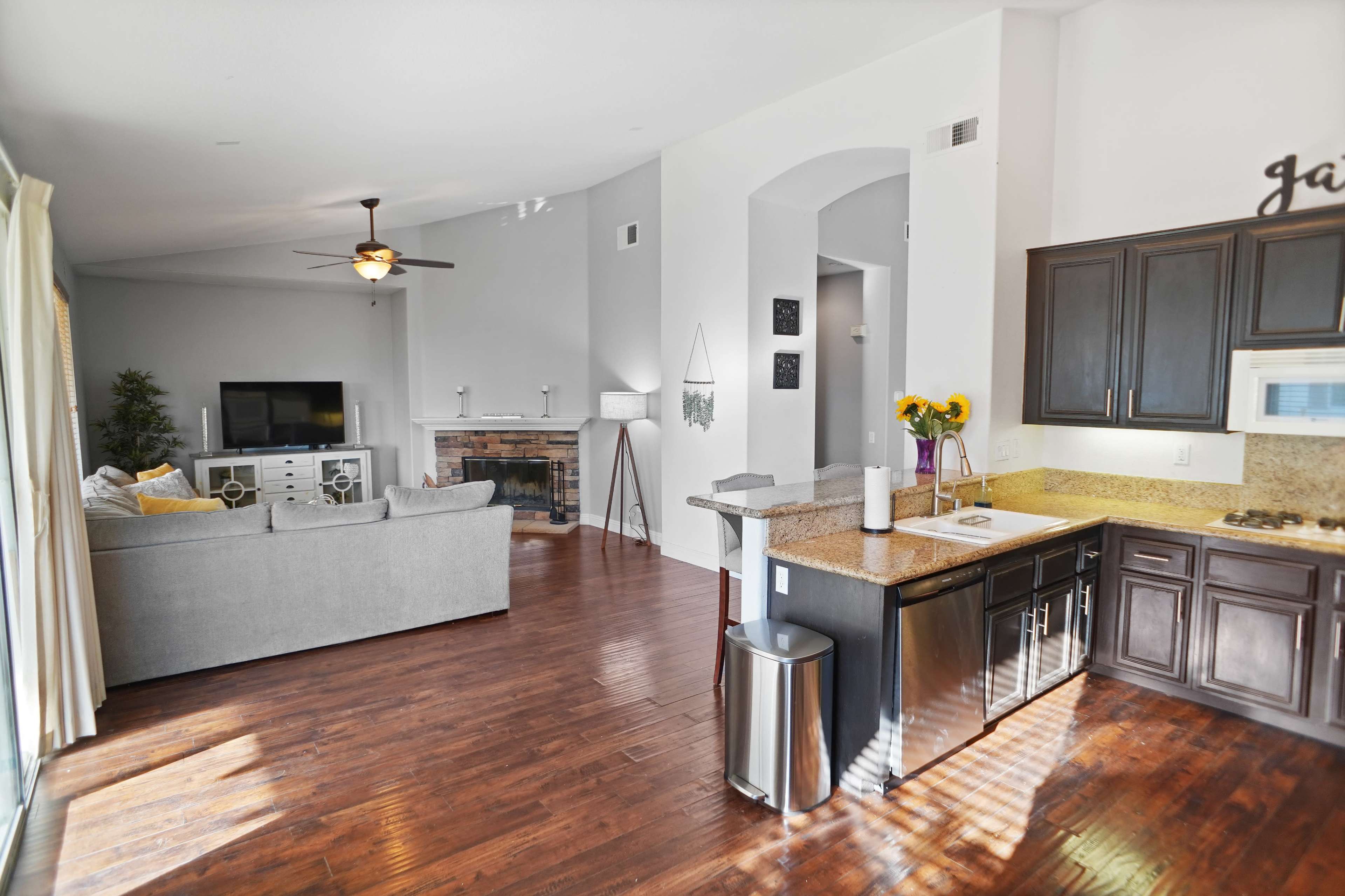 The image features an open-concept living area with a kitchen, dining space, and a cozy seating area near a fireplace.