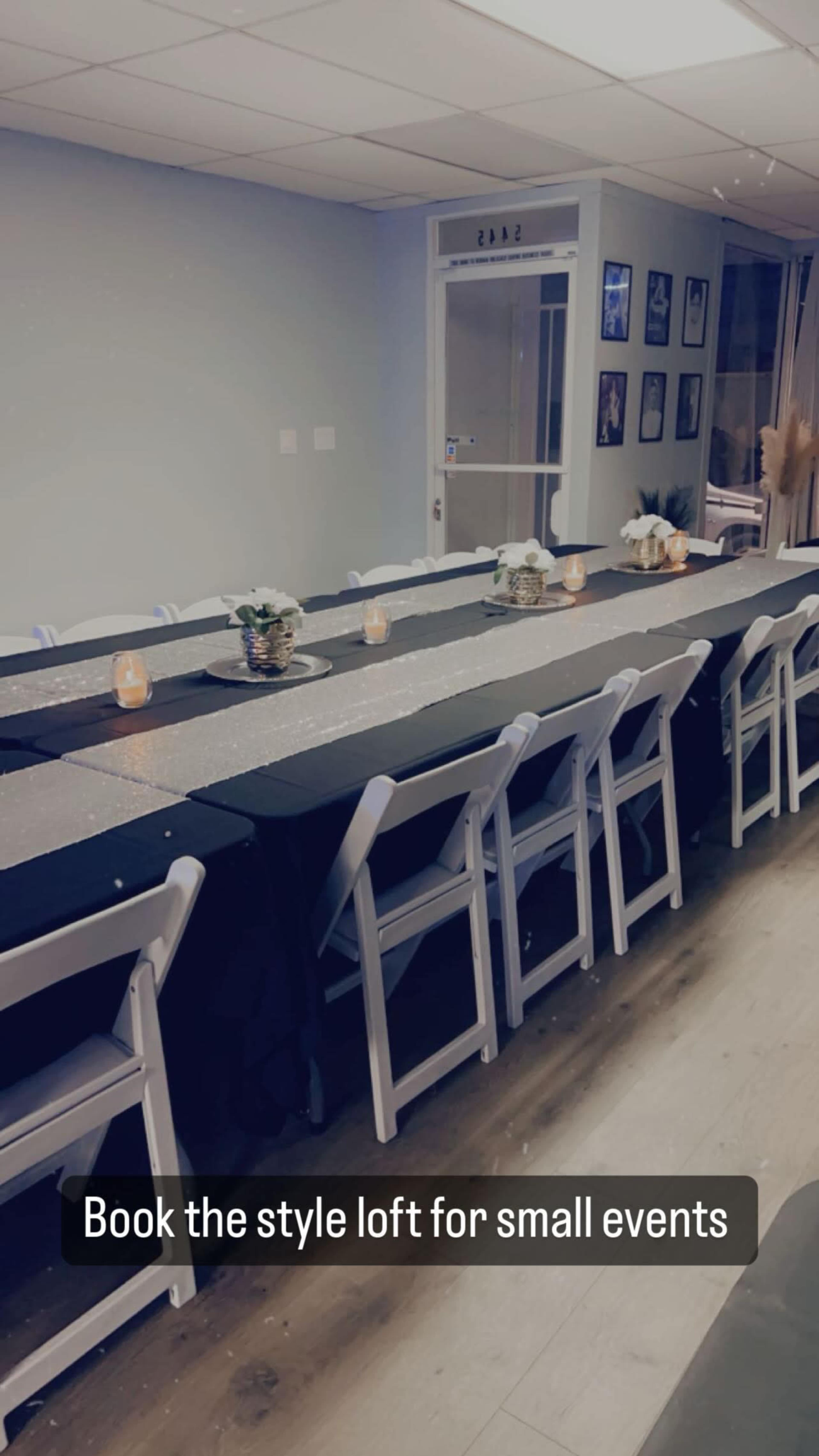 A long table set with decorative centerpieces and candles is arranged in a bright, minimalist room labeled for small events.