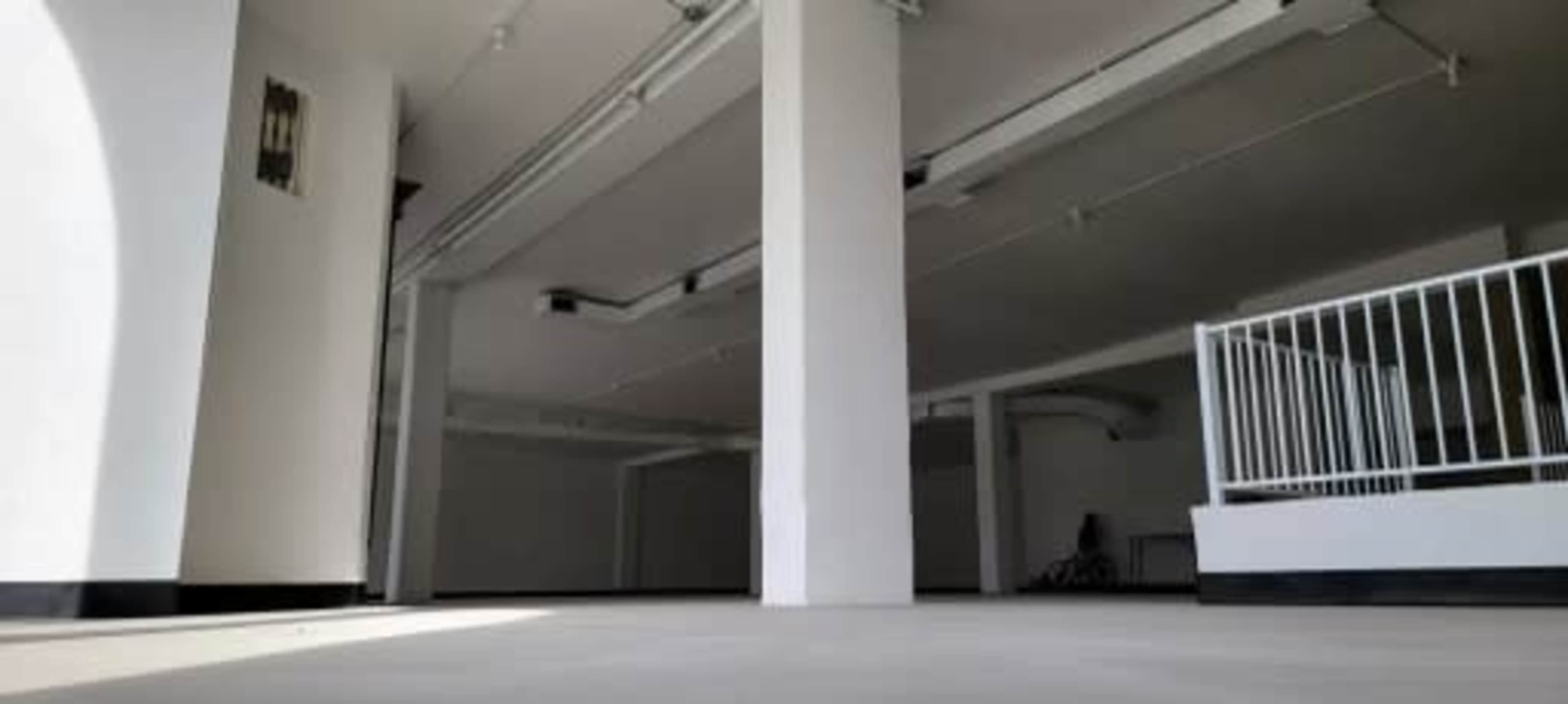 An empty, well-lit interior space with white walls and a smooth floor.