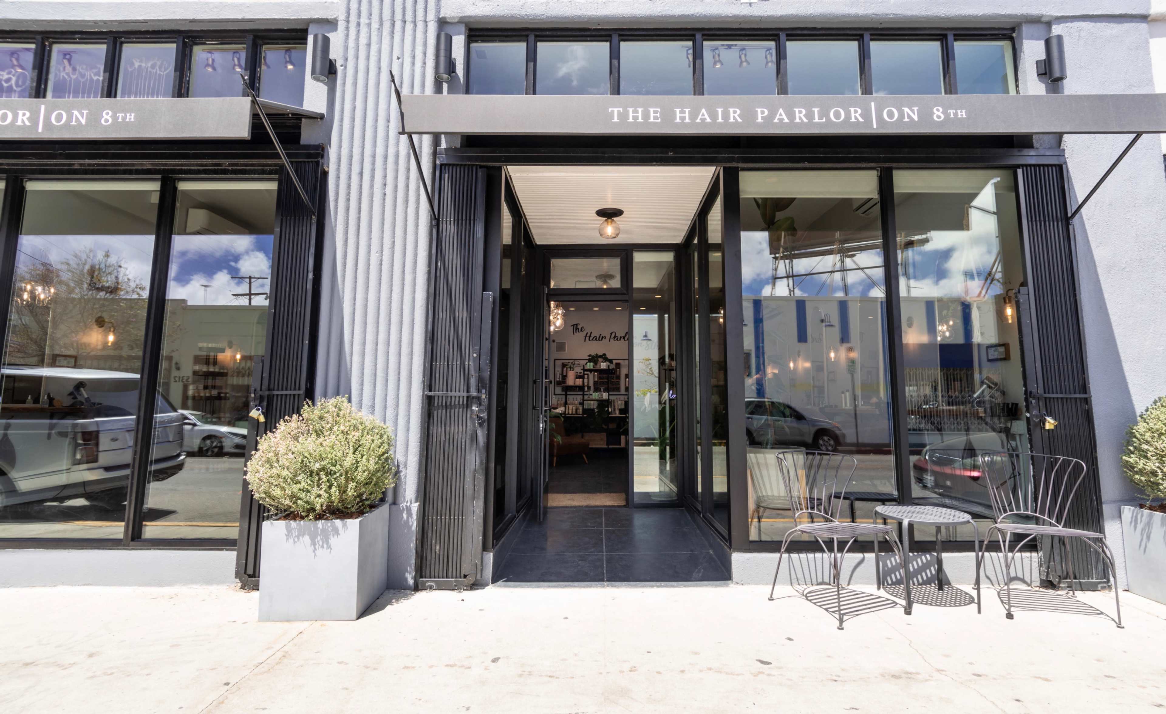 Large open gallery like salon space with brick and wood beams, high ceilings and many plants. Image in Central LA, Los Angeles, CA