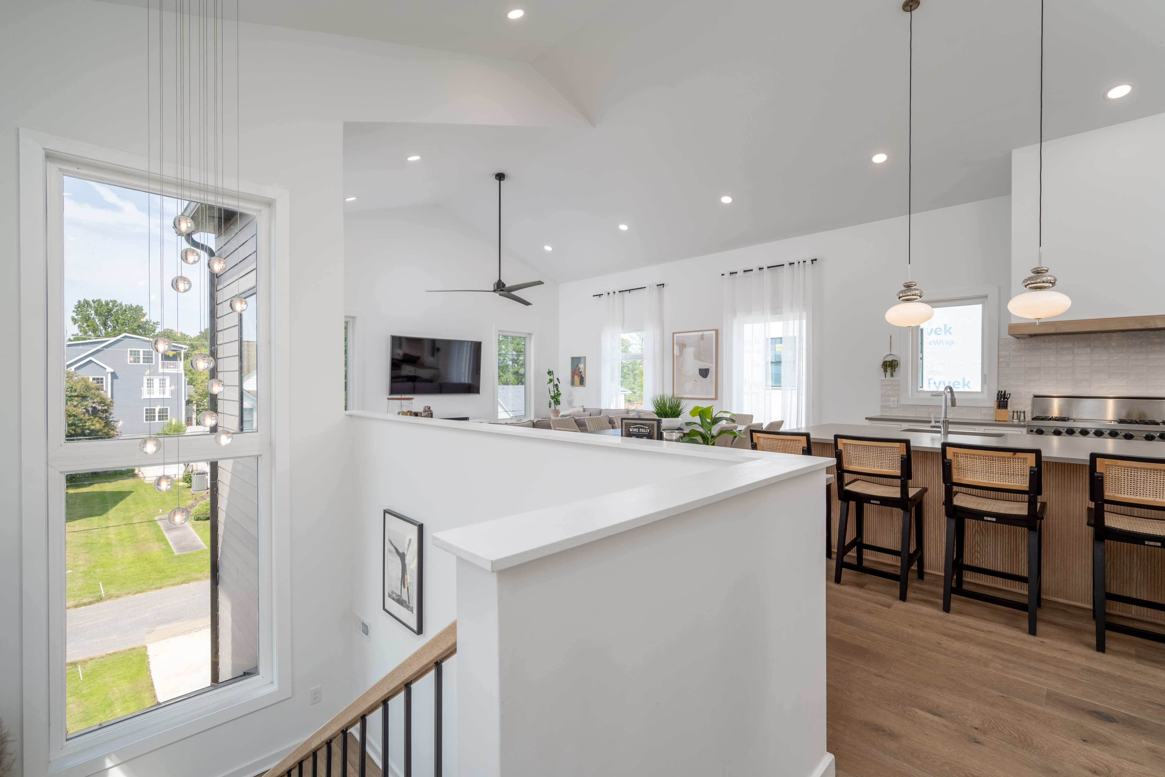 A modern, open-concept kitchen and living area with a staircase leading to the upper level.