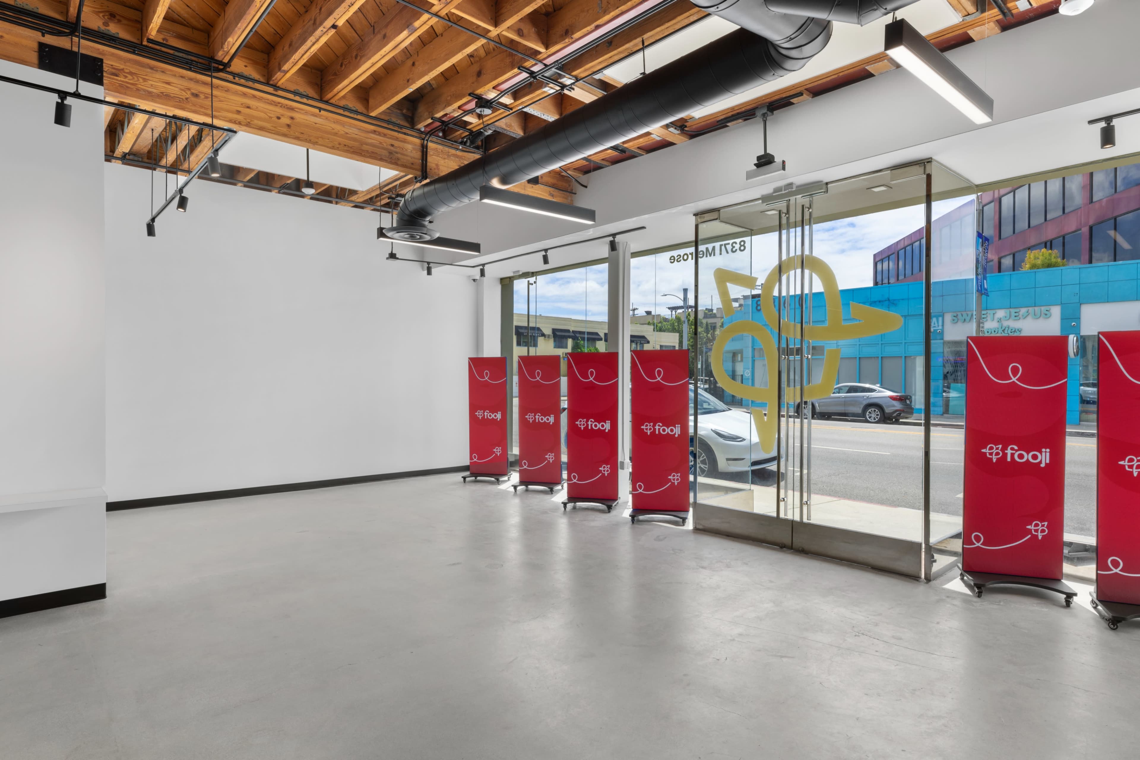 A modern, empty retail space with large glass doors and promotional banners inside.