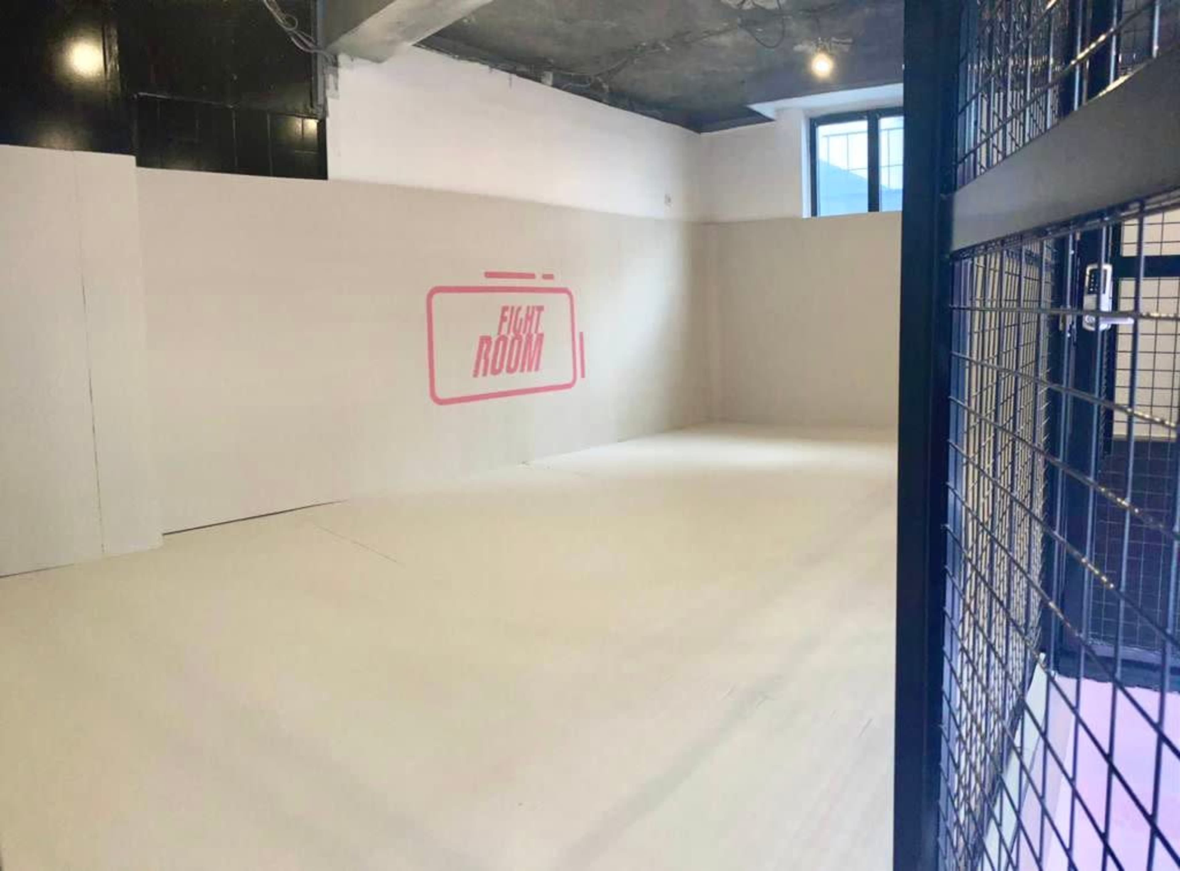 A sparsely decorated room with white walls and a large sign that reads "FIGHT ROOM."