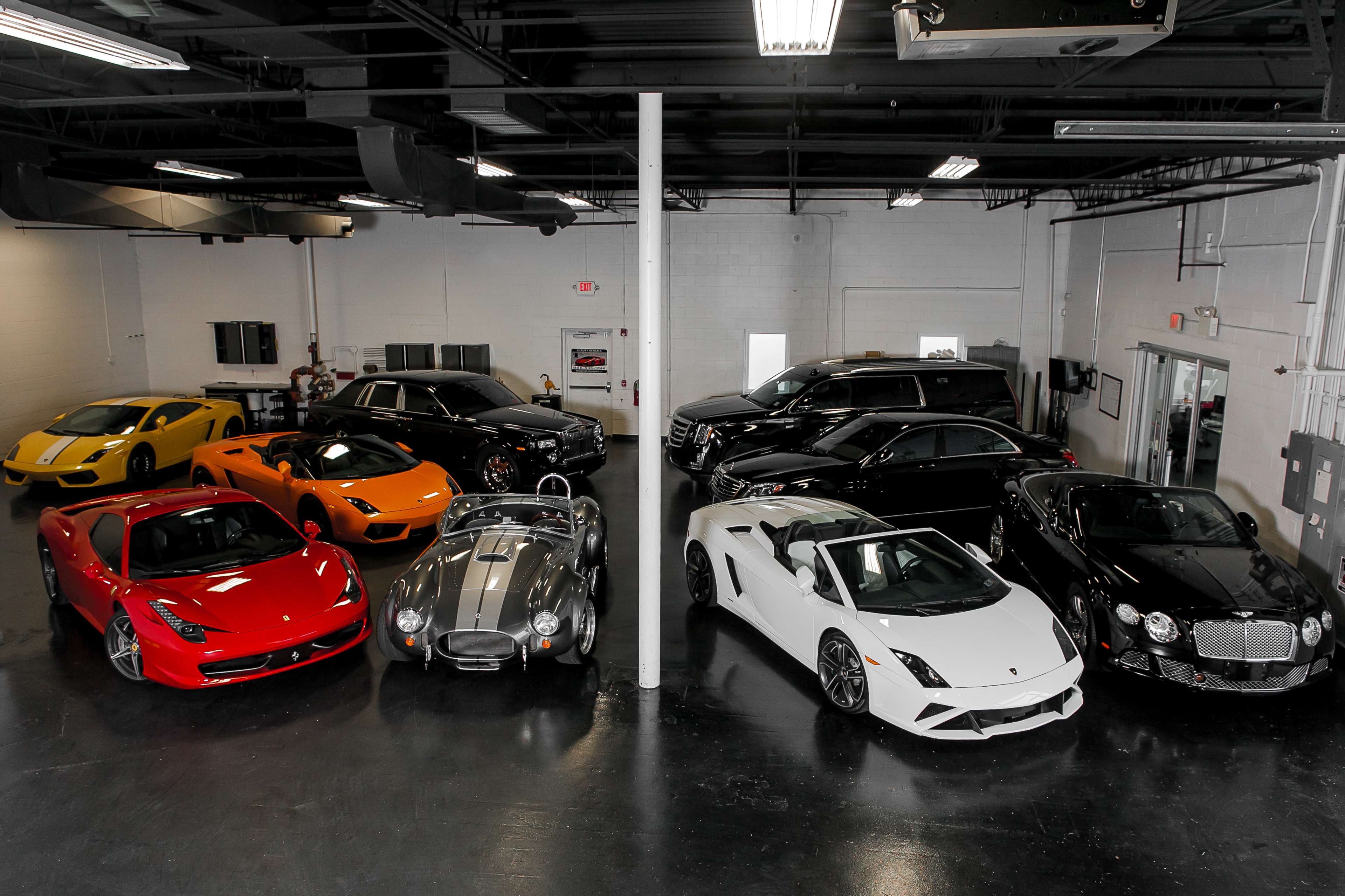 A collection of luxury and sports cars parked in a spacious garage.