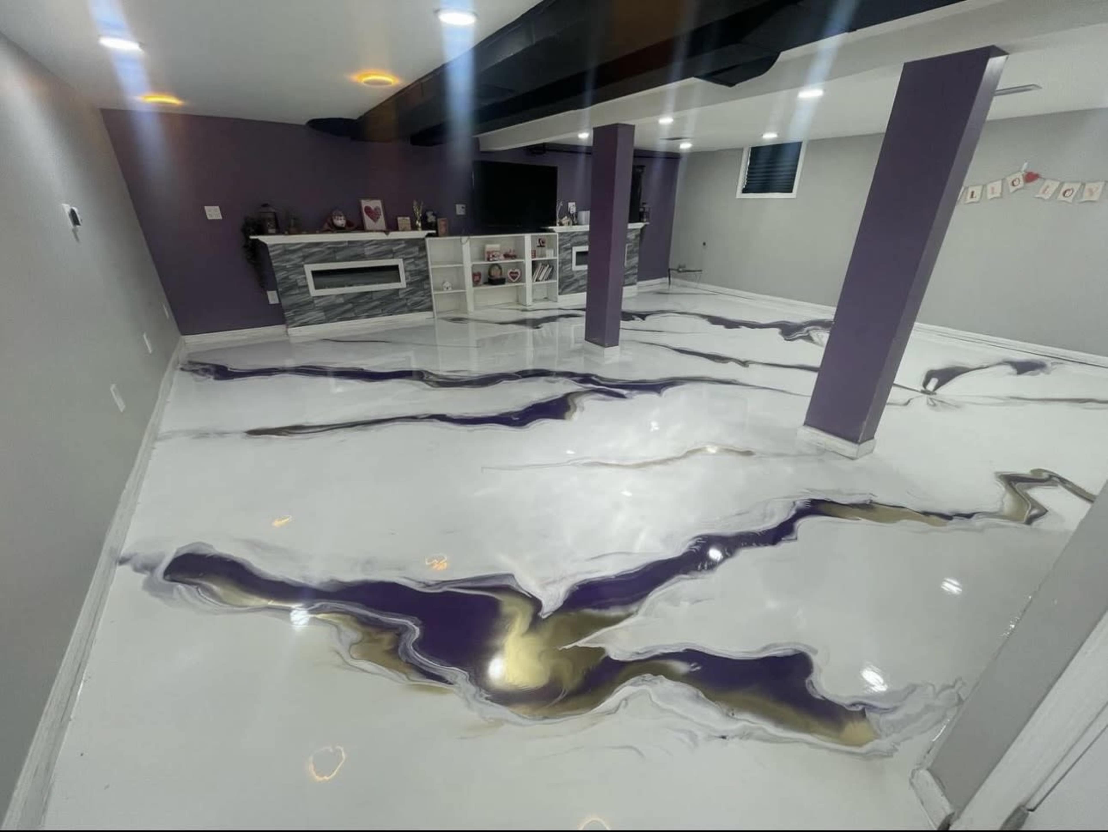The image shows a basement with a glossy white floor featuring purple and gold marbled patterns, and purple walls with a shelving unit in the background.
