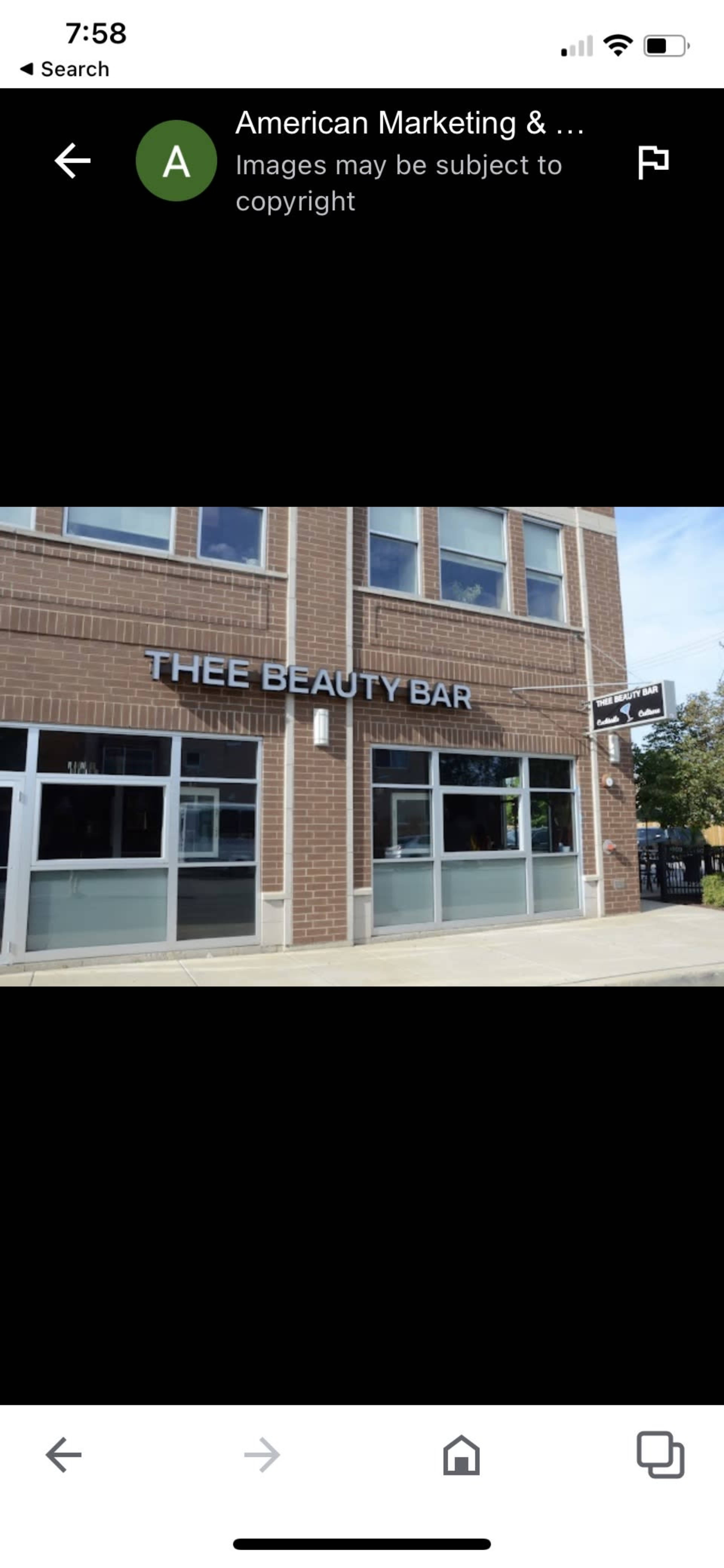 A brick building with large windows and a sign reading "THEE BEAUTY BAR."