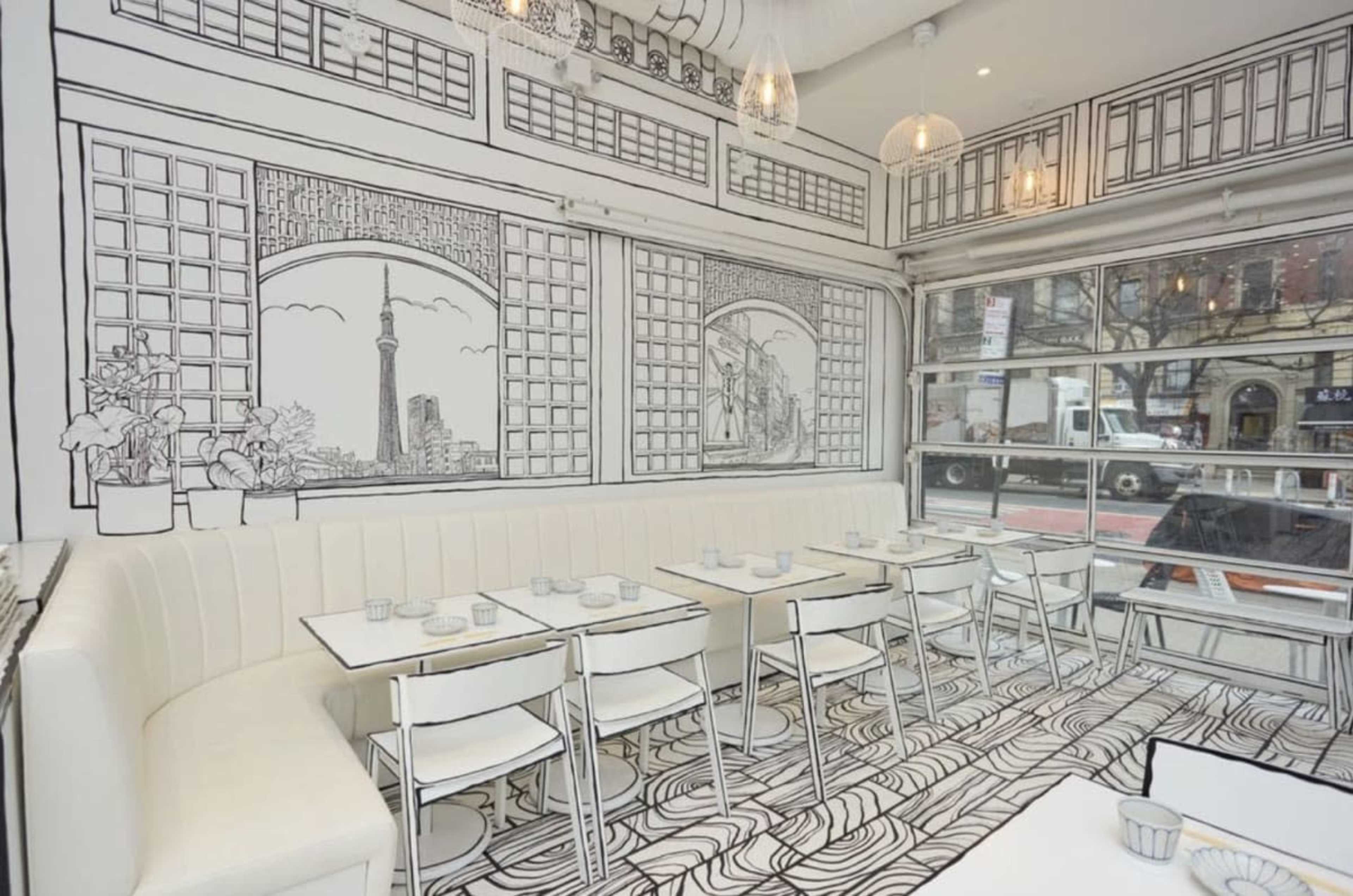 The image shows a modern restaurant interior featuring white furniture and black-and-white illustrated walls depicting cityscapes and architectural features.