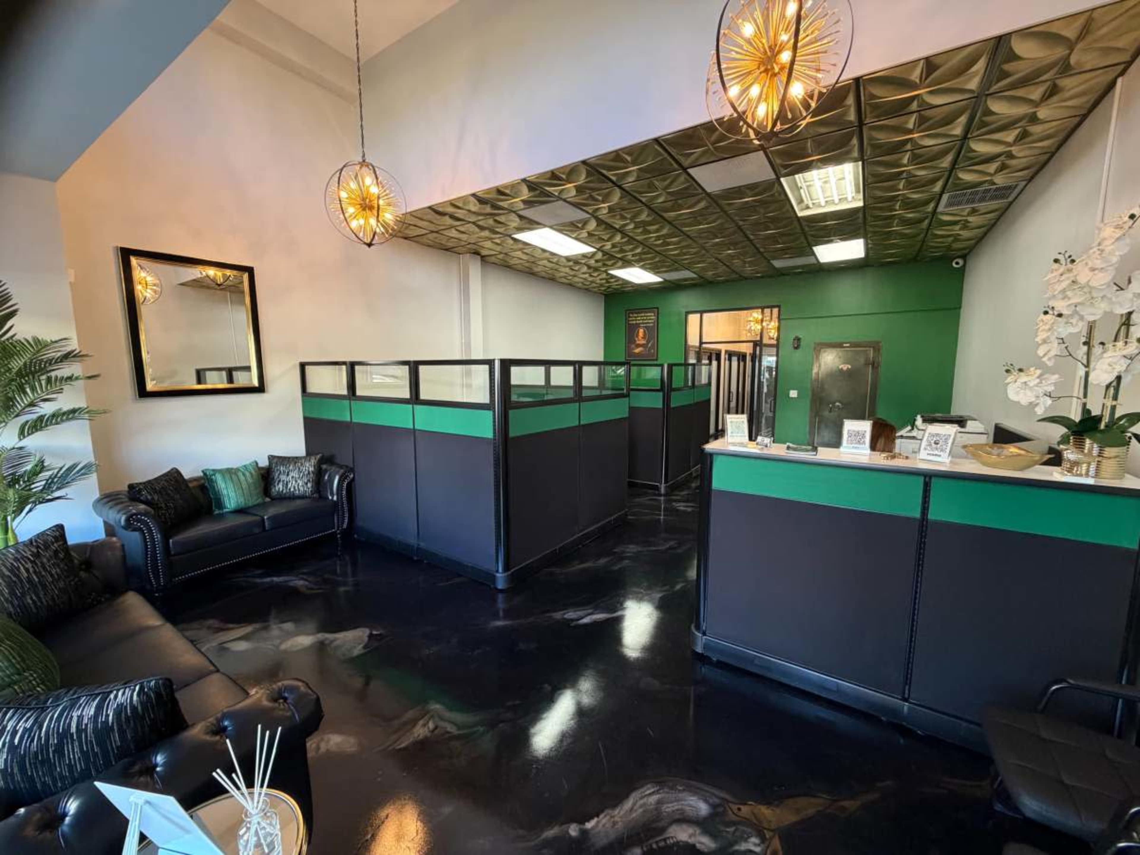 The image shows a modern reception area with a black and green color scheme, featuring a dark sofa, decorative lighting, and partitioned sections for privacy.