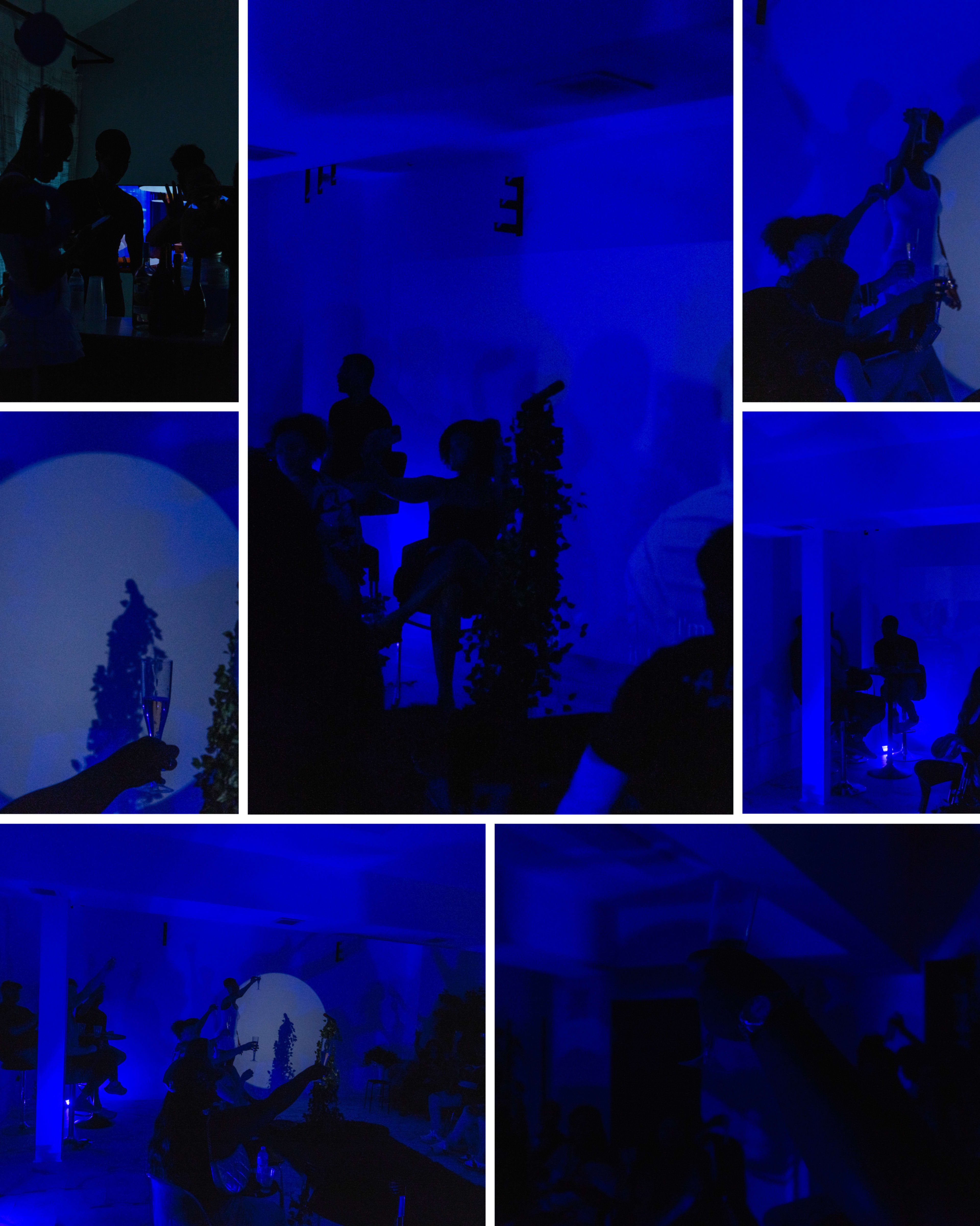 A dimly lit room features people interacting with projected shadows and blue lighting, creating a vibrant atmosphere.