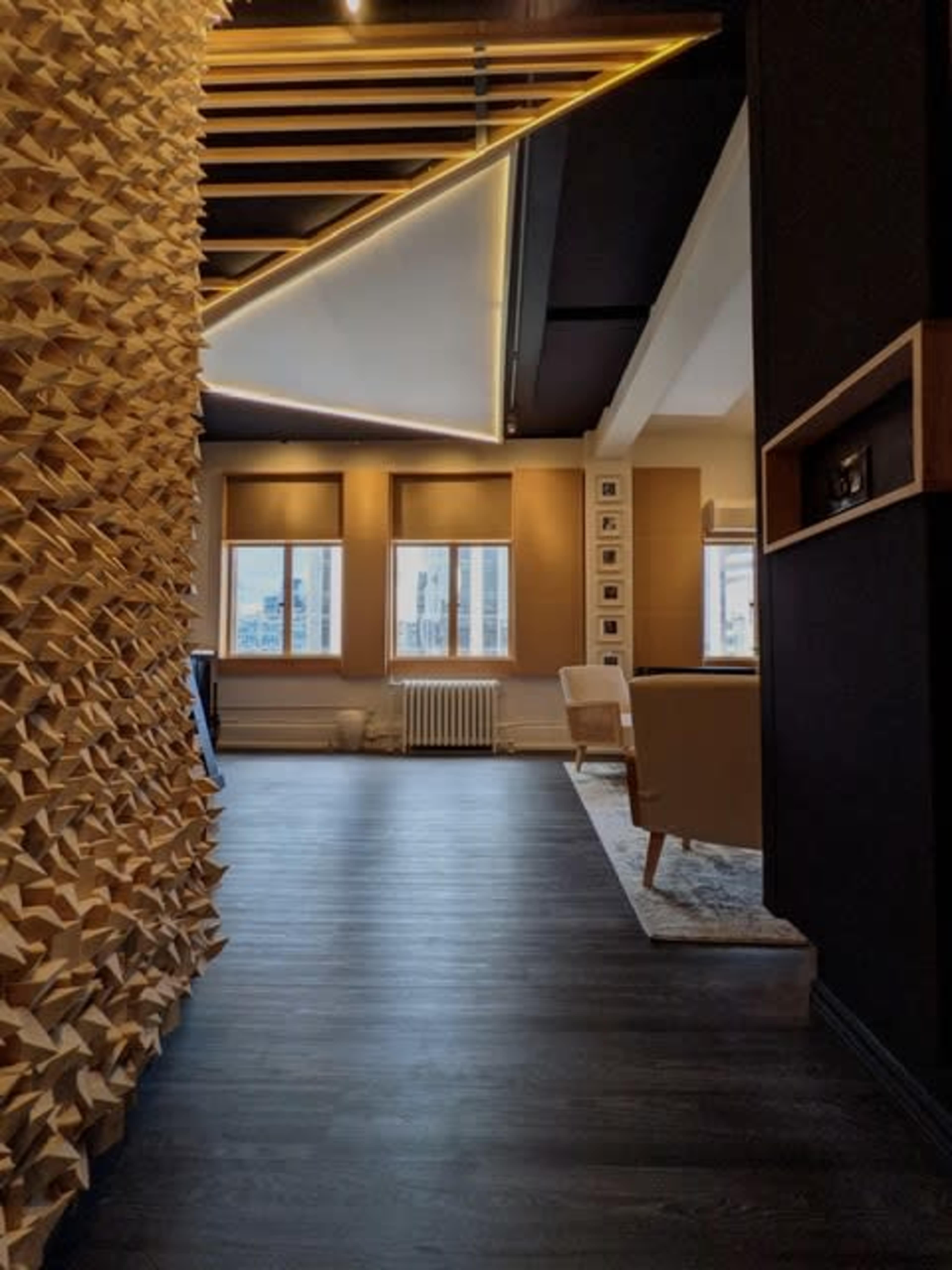 A modern interior space with wooden architectural features, large windows, and a view of the city.