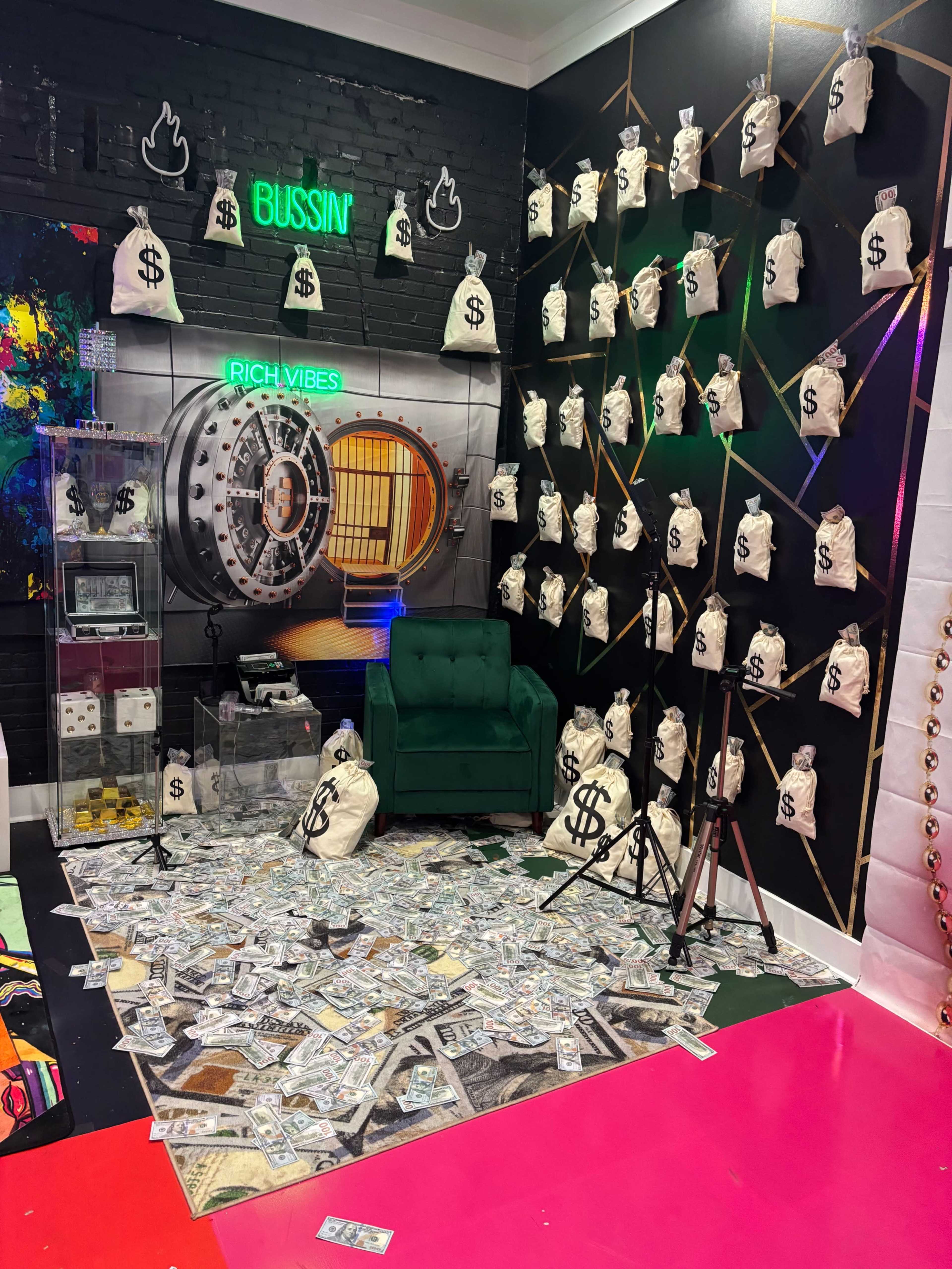 The image depicts a vibrant room decorated with a green couch, a wall featuring a bank vault, and numerous bags marked with dollar signs scattered across the floor.