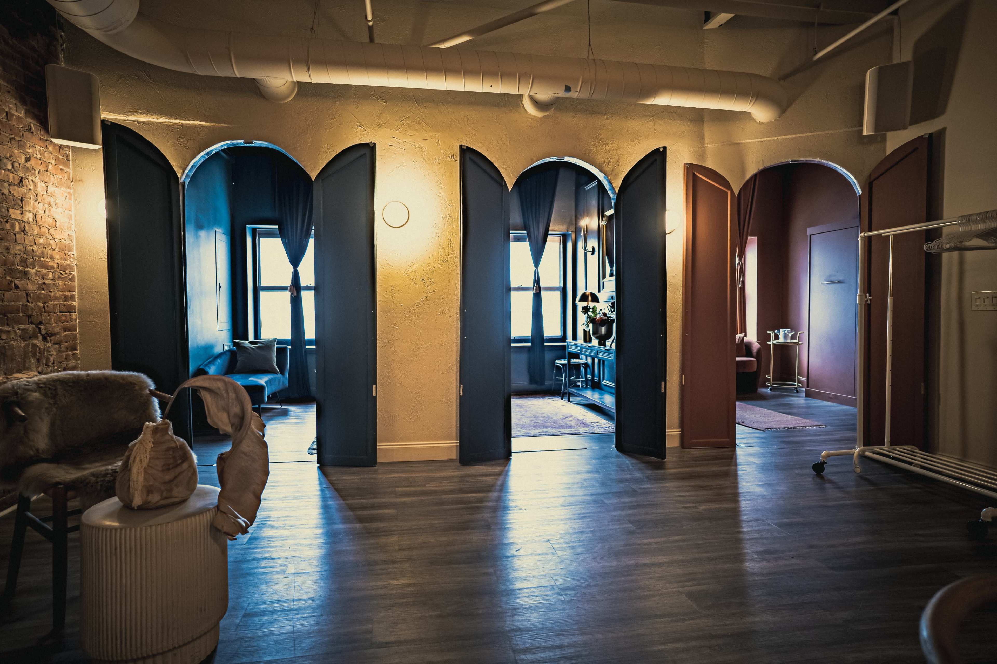 The scene features a spacious interior with multiple arched doorways leading into separate rooms, illuminated by soft lighting.