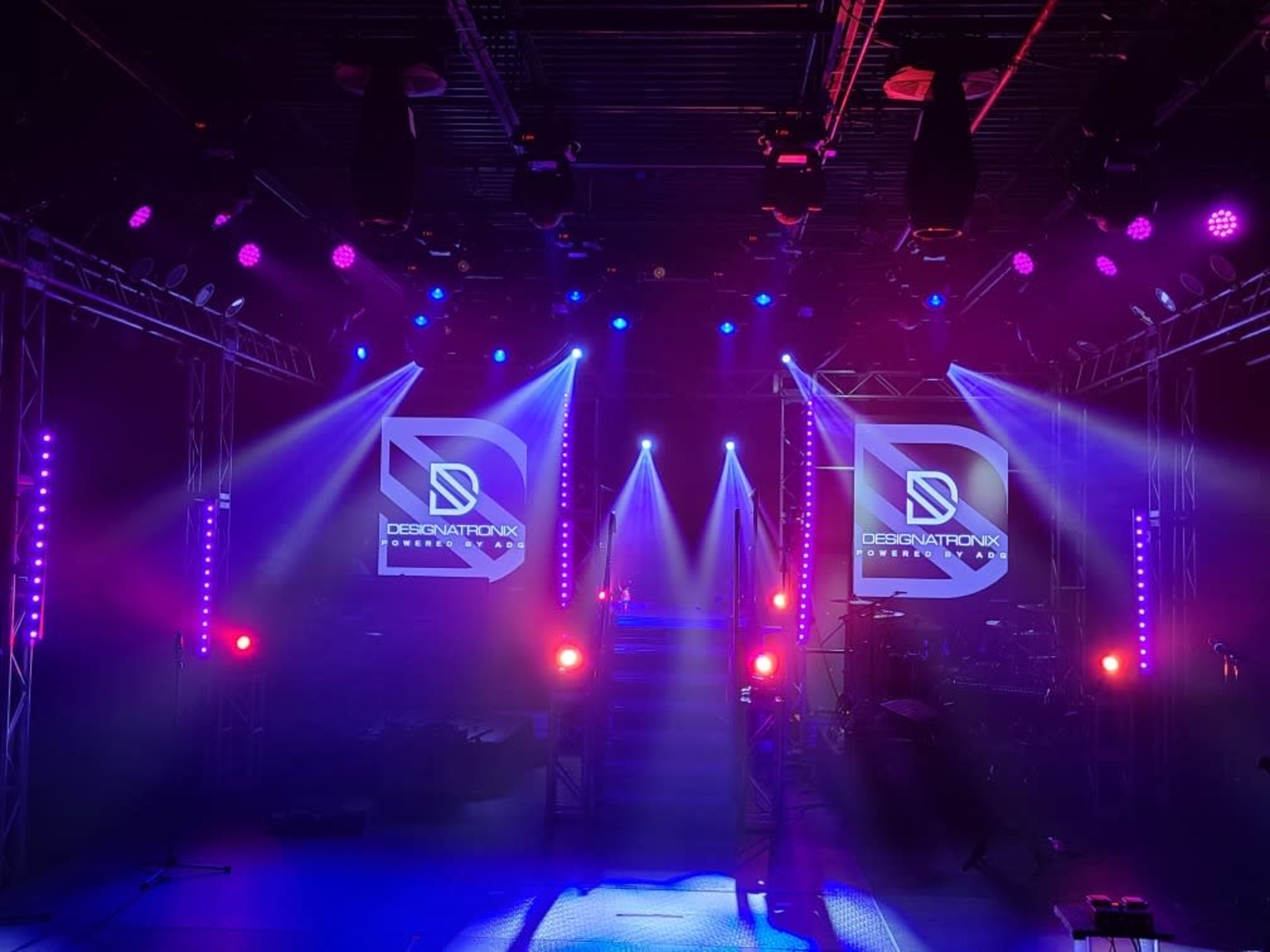 A well-lit stage setup featuring digital displays and colorful lights arranged for a performance.