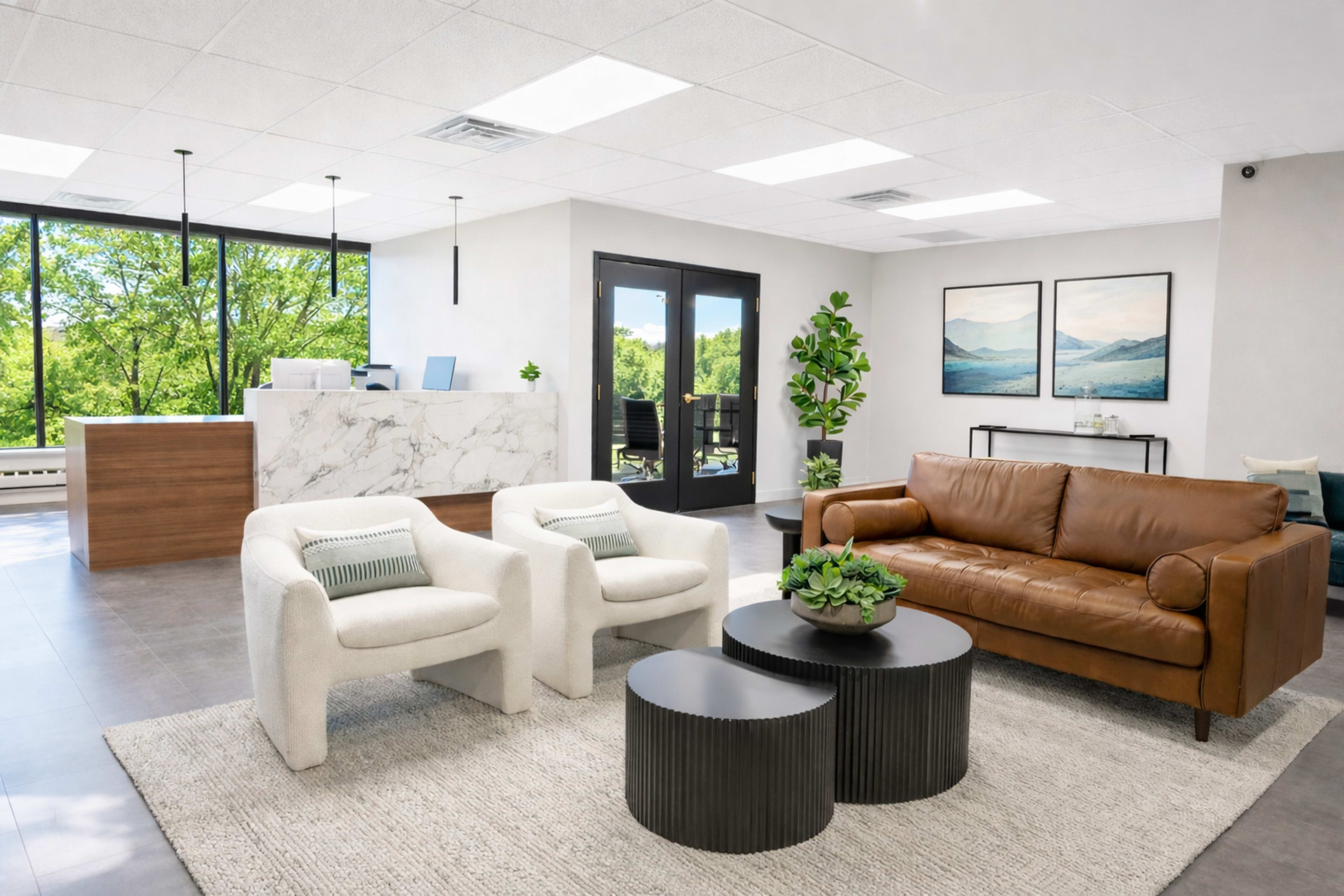 The image shows a modern reception area with a marble front desk, seating arrangements including a brown leather couch and white armchairs, and large windows overlooking greenery.