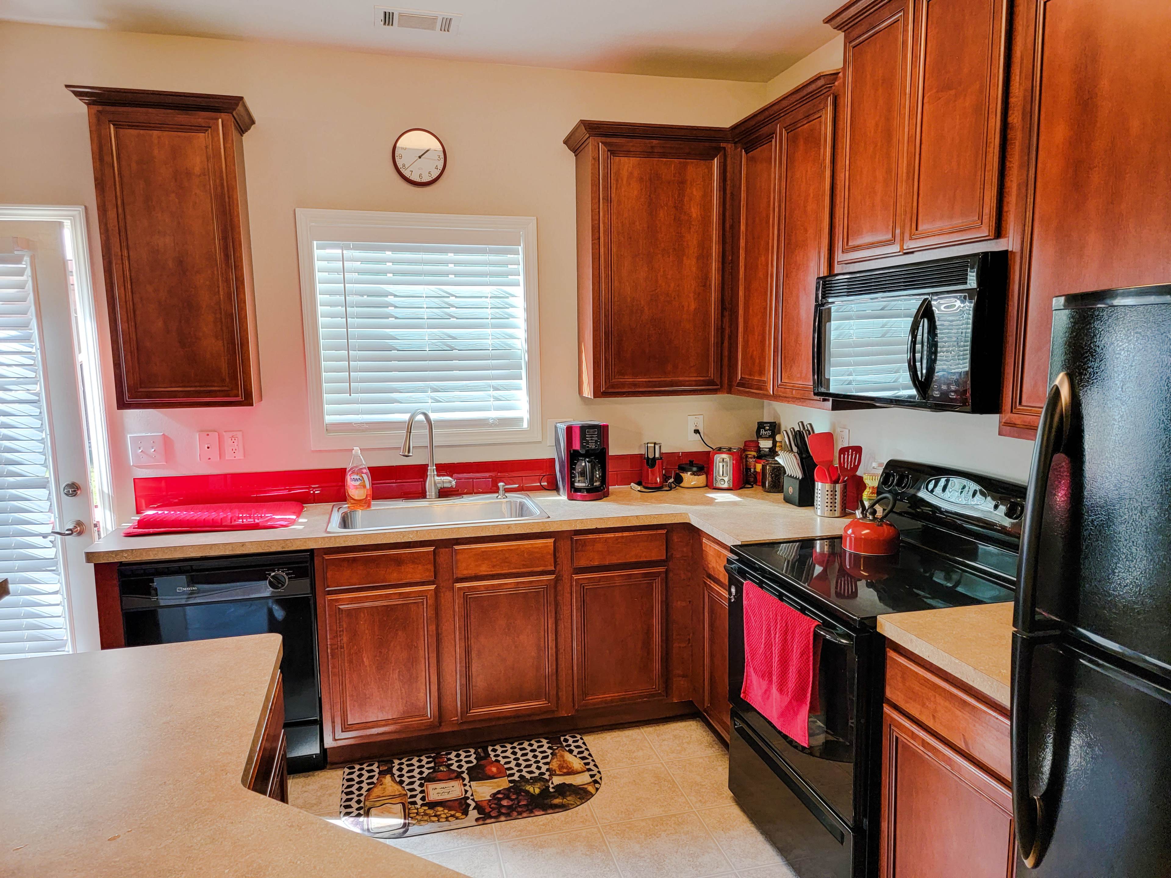 The kitchen features wooden cabinets, dark appliances, and a countertop with a sink and various kitchen appliances.