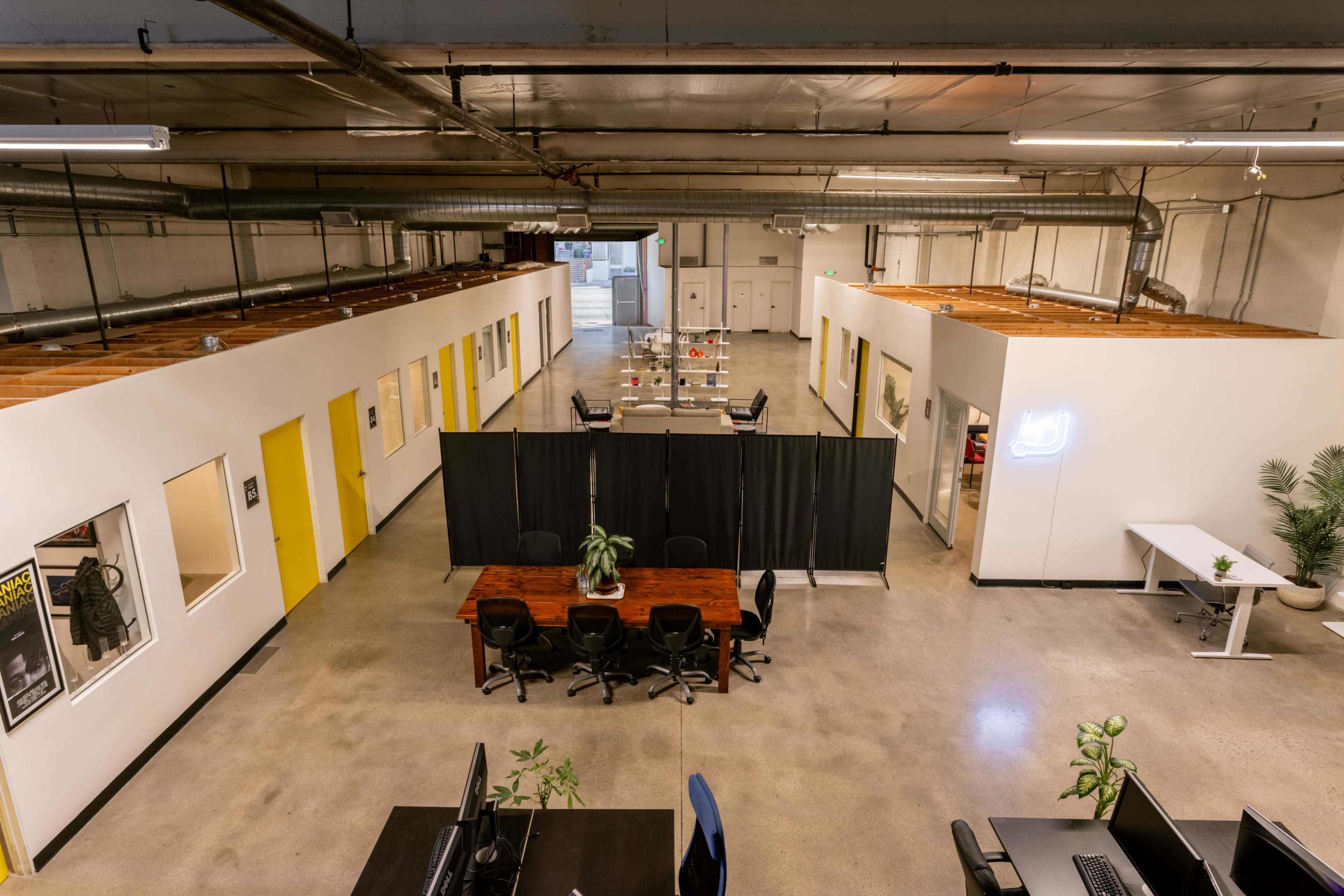 An open office space with a central meeting area and several workstations along the perimeter.