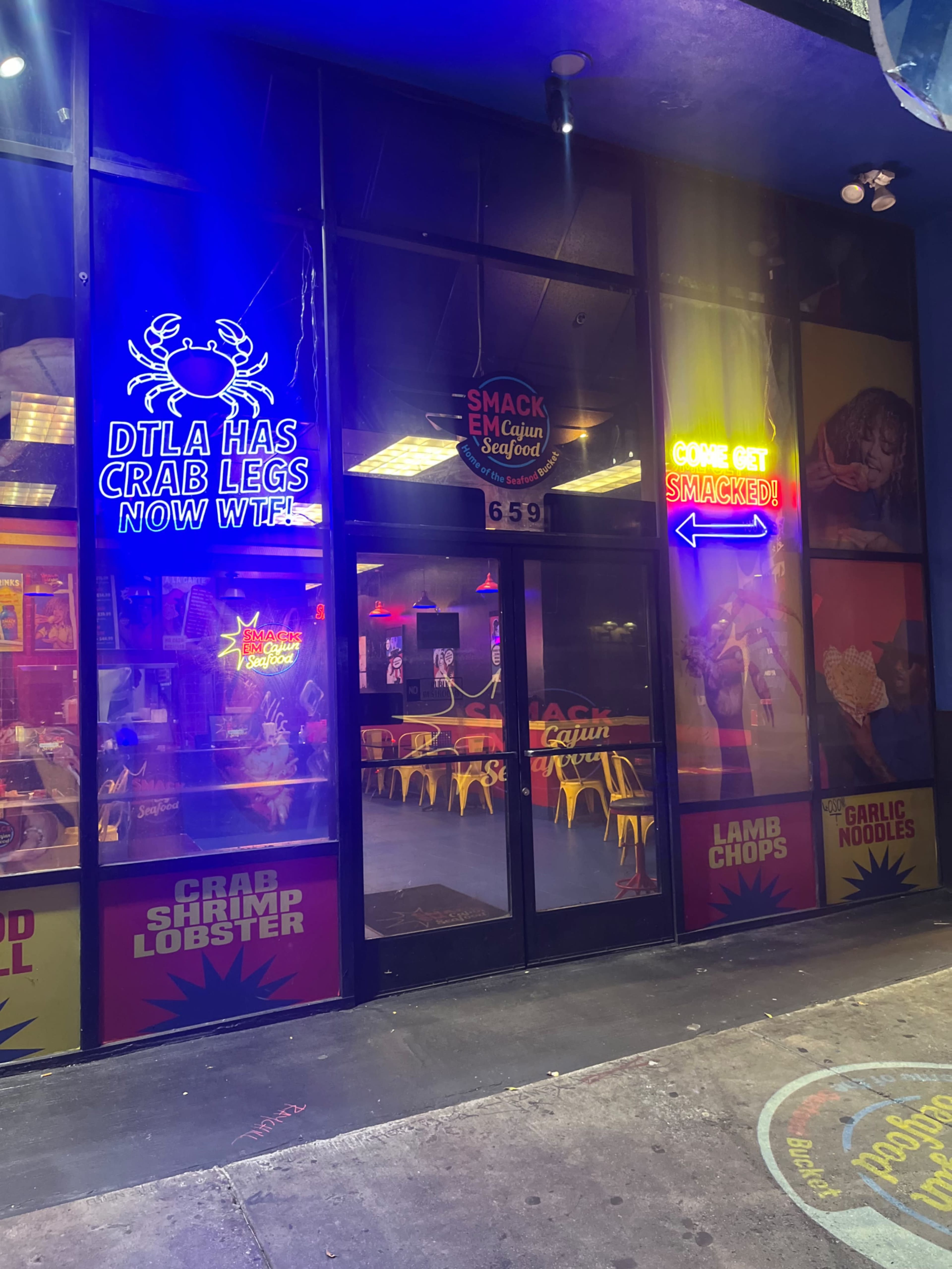 The image shows a brightly lit seafood restaurant with neon signs displaying various menu items and promotions.